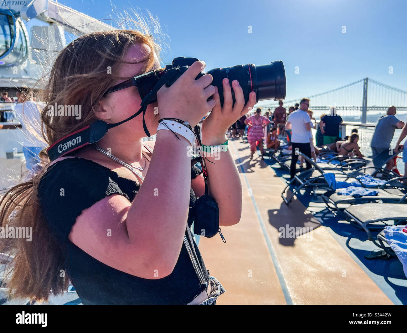 Giovane donna che scatta foto con una fotocamera canon durante una crociera a Lisbona, Portogallo Foto Stock
