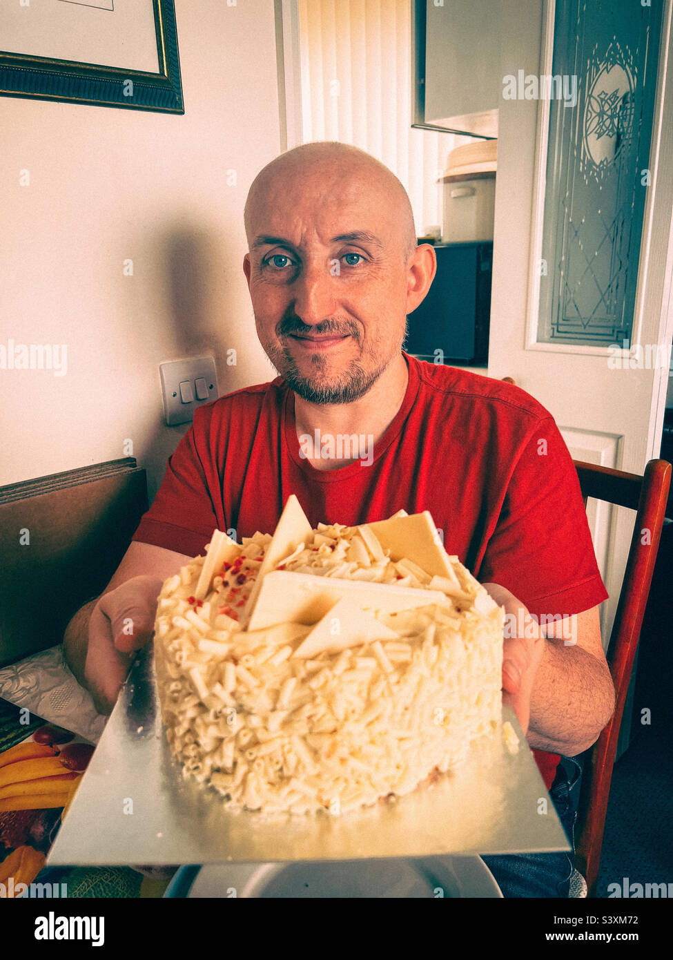 L'uomo alla fine del 40s festeggia un altro compleanno con una torta al cioccolato bianco. Foto Stock