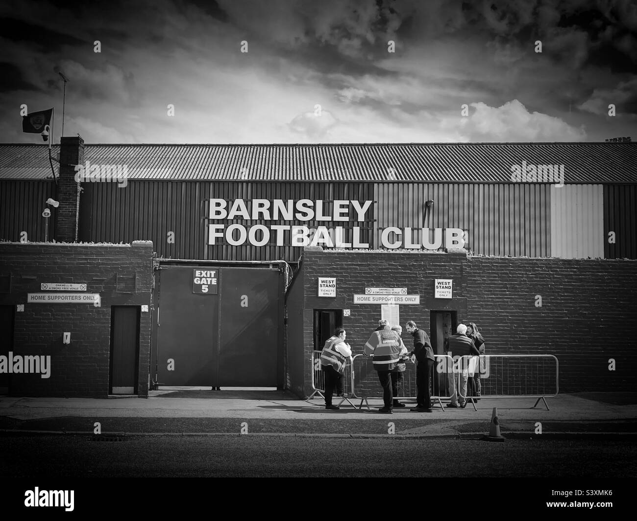 I fan di casa 'Back Again' iniziano ad arrivare ai tornelli East Stand, Oakwell, Barnsley prima della corsa successiva, quando si avvicina il calcio d'inizio (Black & White) Foto Stock