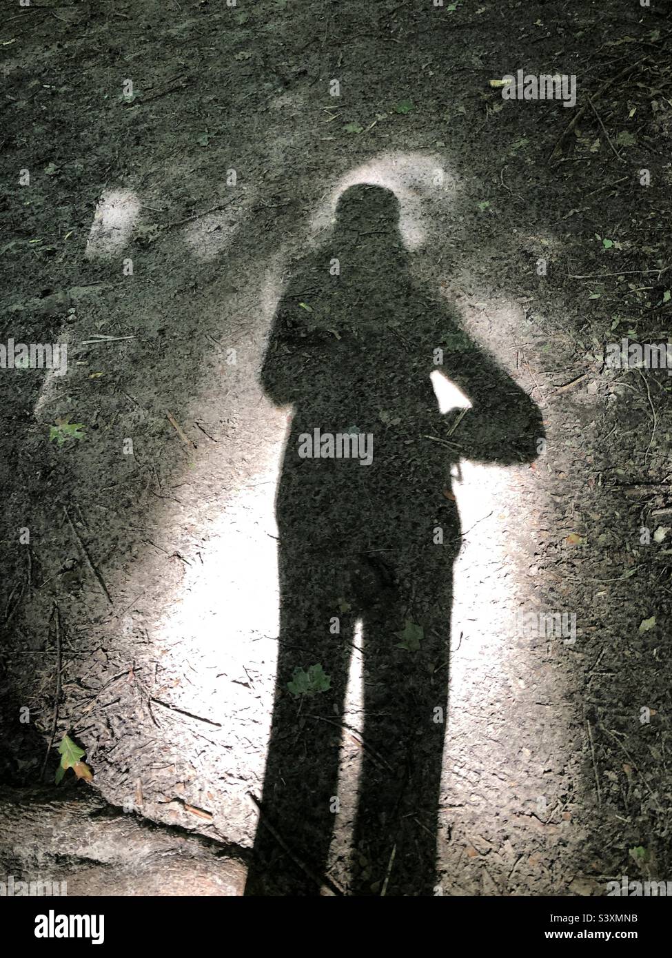 Un'ombra femminile in piedi nella luce. - Immagine stock catturata con smartphone