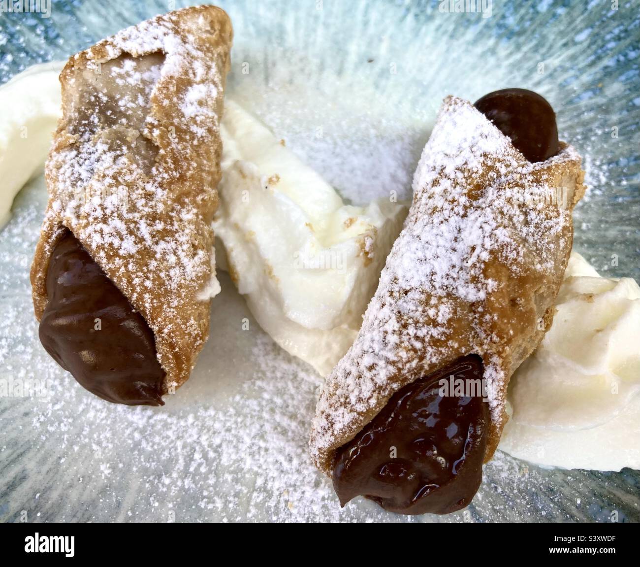 Dessert di pasta al cioccolato con panna e zucchero a velo su un piatto decorativo - Immagine stock catturata con smartphone
