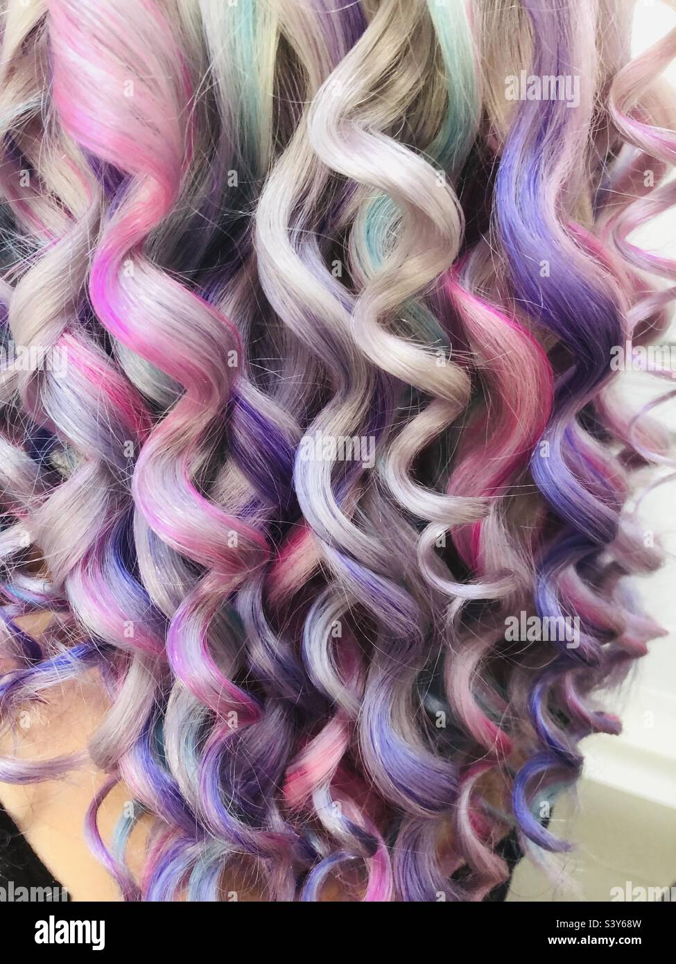 Creazione di capelli colorati arcobaleno su bionda ondulata Foto Stock