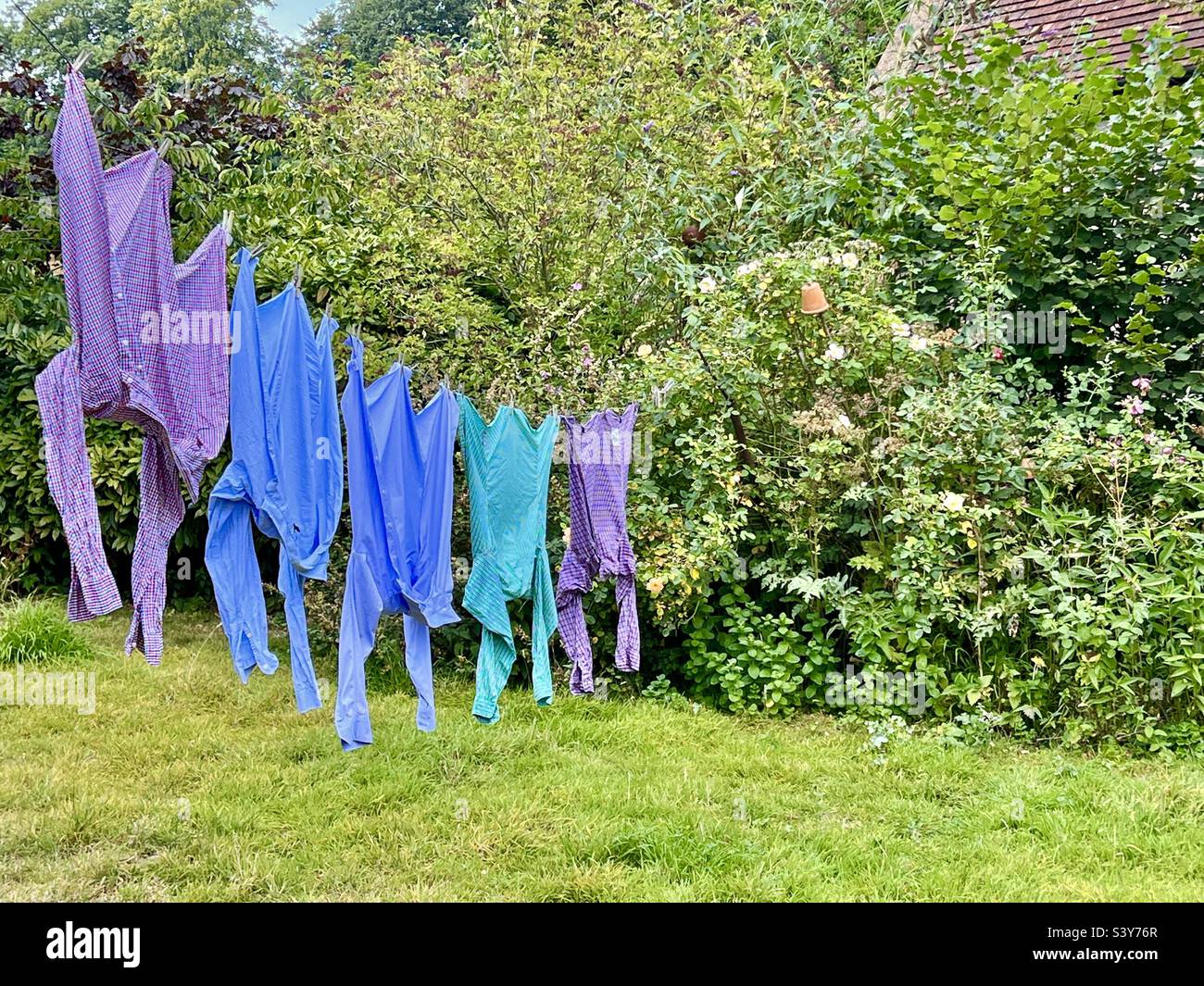 Camicie appese alla linea di lavaggio per asciugare in un giardino estivo in Inghilterra Foto Stock