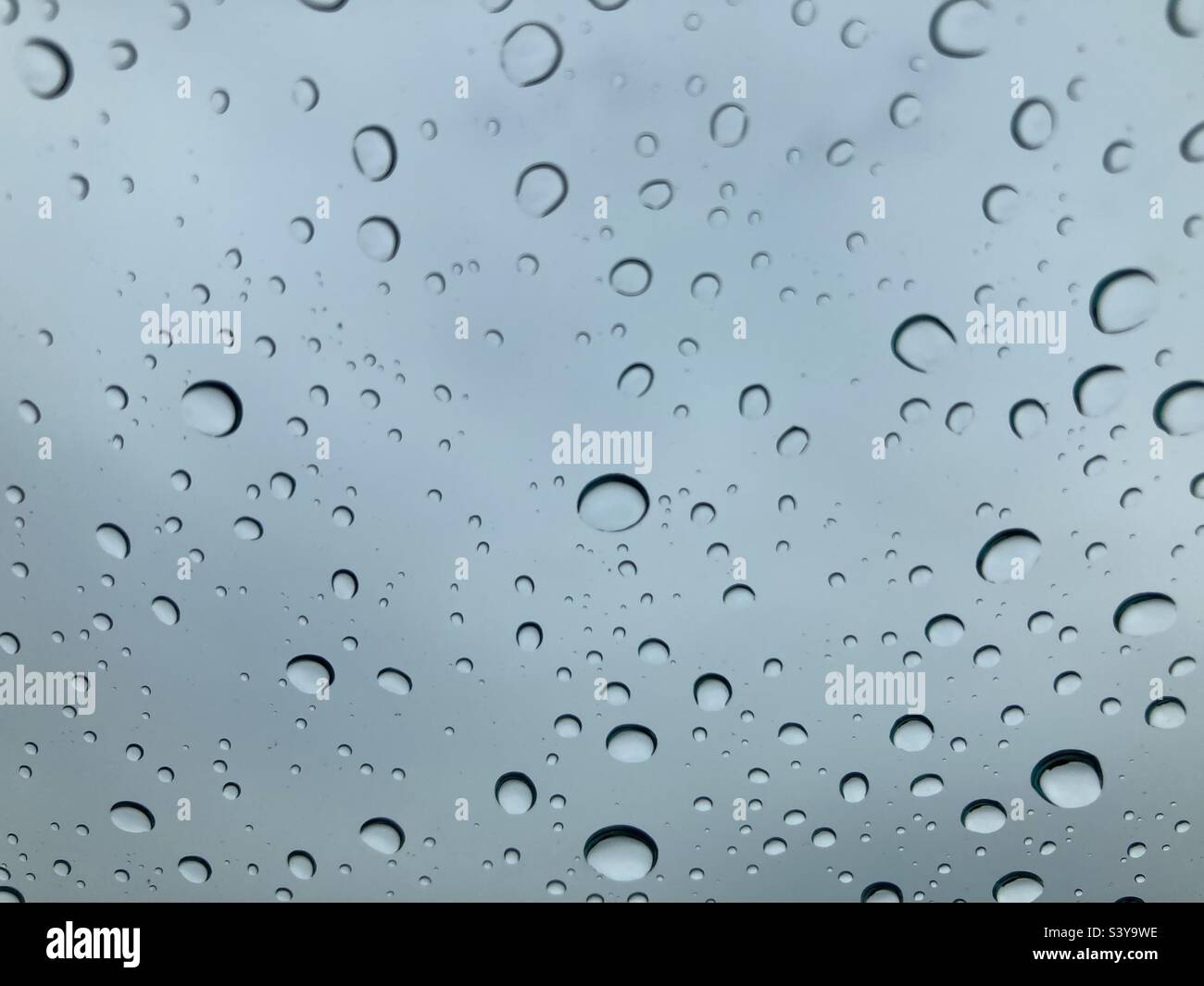 Pioggia sul finestrino dell'auto in una giornata nuvolosa Foto Stock