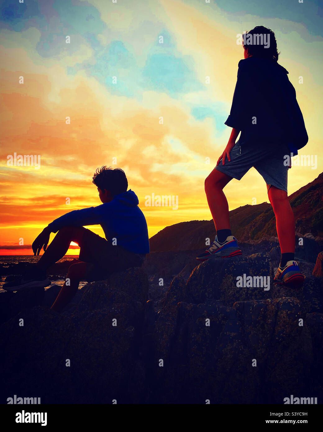 2 amici che guardano il tramonto vicino all'oceano - Immagine stock catturata con smartphone