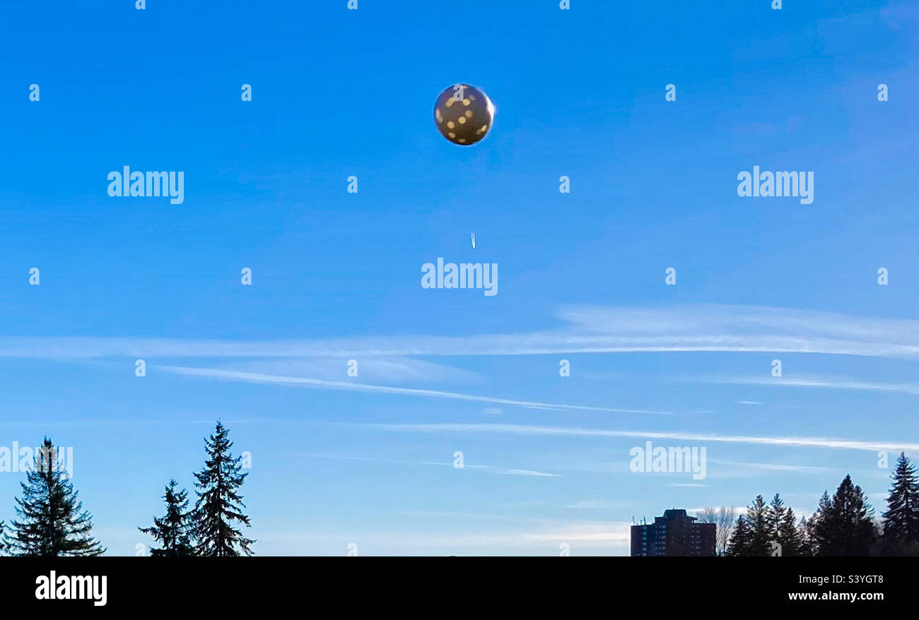 Palla di pickle che inarcata attraverso il cielo con un corto getto ruscello sullo sfondo. Foto Stock