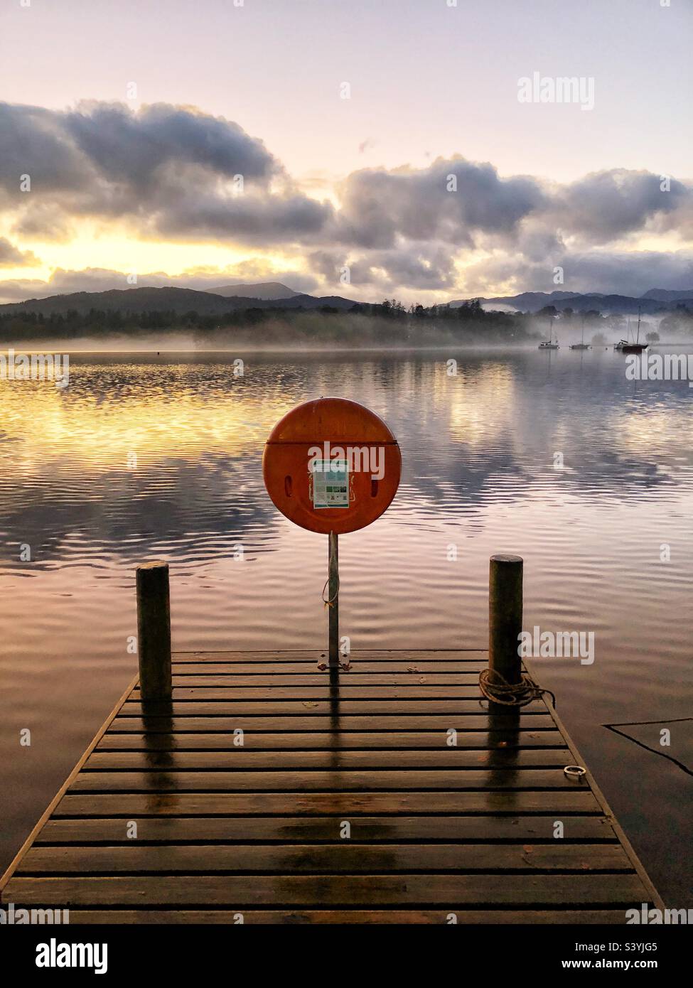 Molo in legno sul lago Windermere al tramonto, Cumbria Lake District - Immagine stock catturata con smartphone
