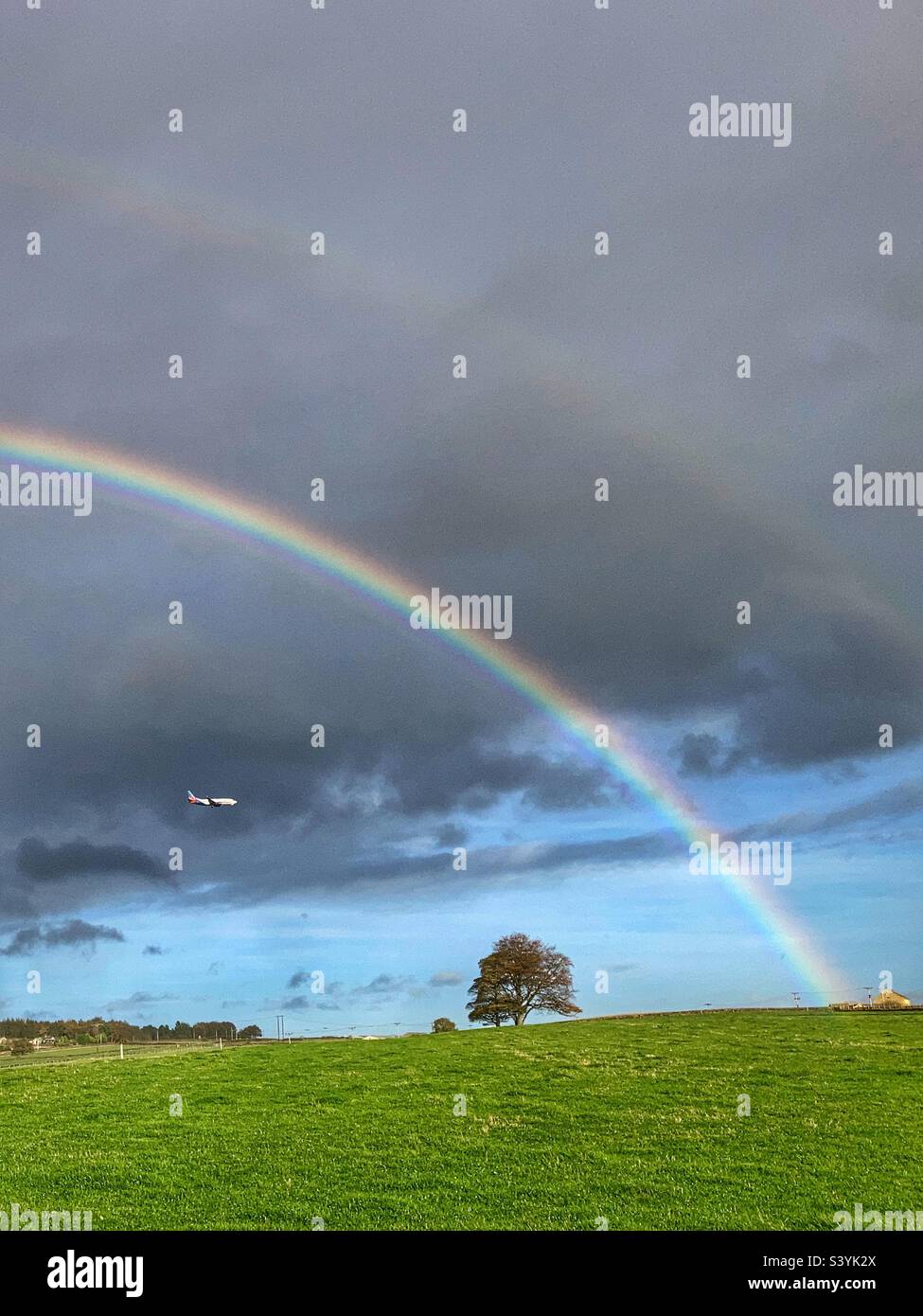 Velivolo in avvicinamento all'aeroporto di Leeds Bradford sotto un doppio Rainbow sul Chevin Otley West Yorkshire Foto Stock