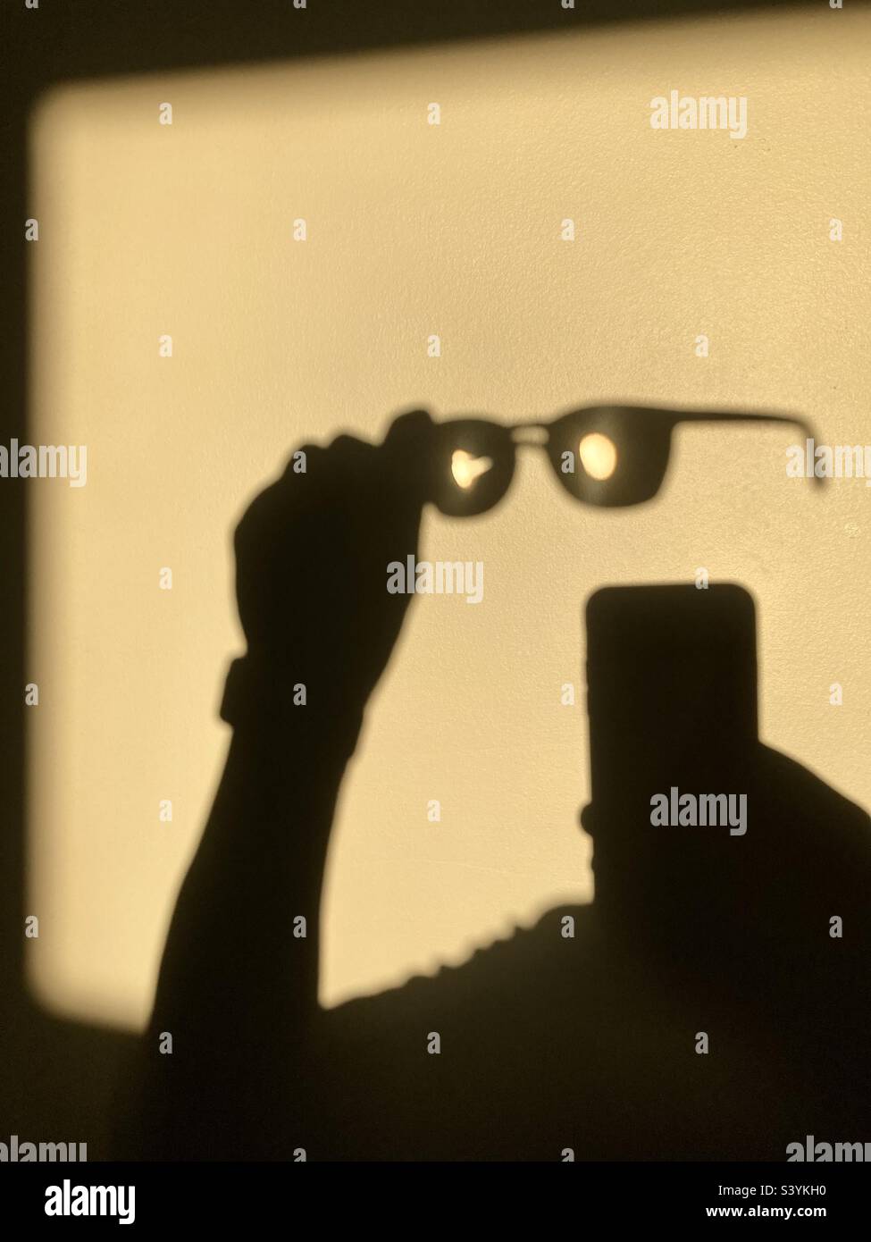 Shadow crea un uomo invisibile che guarda il suo telefono. Foto Stock