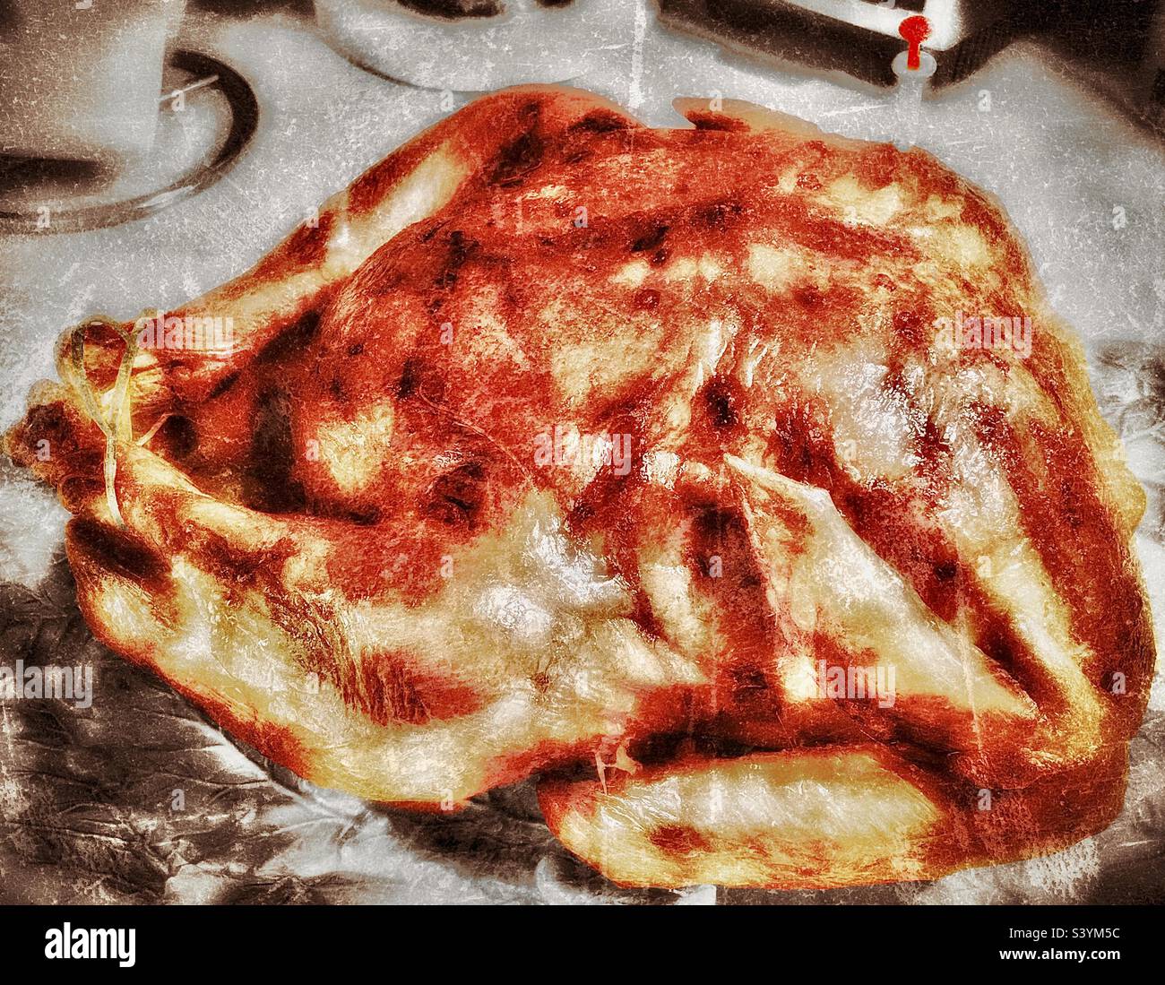 Un tacchino del Ringraziamento marrone dorato, fresco dal forno, viene posto su un piatto autunnale e siede su un piano di cucina fresco, prima di essere scolpito per la cena. Foto Stock