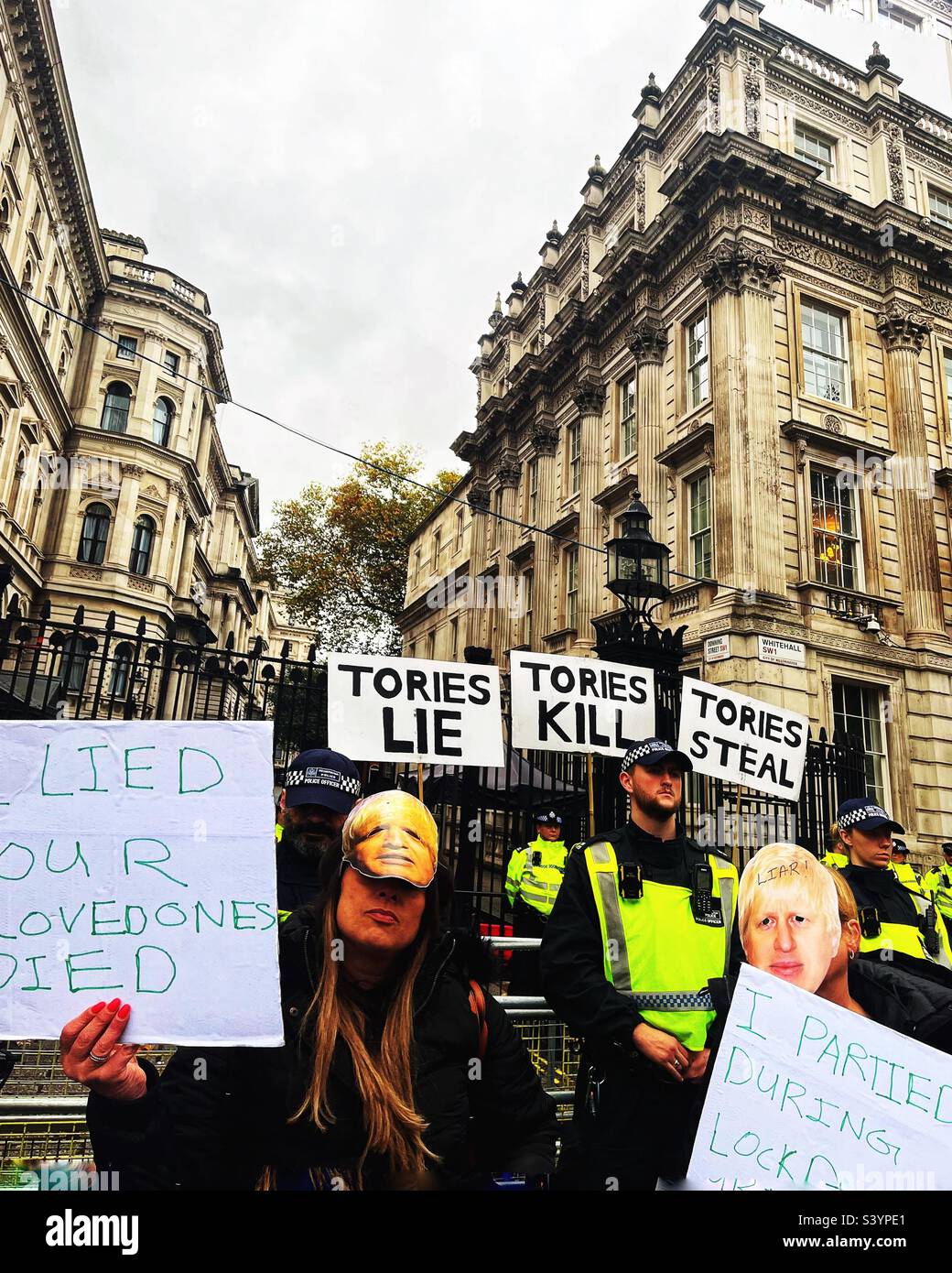 Manifestanti al di fuori di Downing Street, sede del primo ministro e del governo del Regno Unito. I cartelli leggono Tories, Kill e rubano. I dimostranti mascherati criticano l'aderenza e l'ipocrisia del blocco Foto Stock