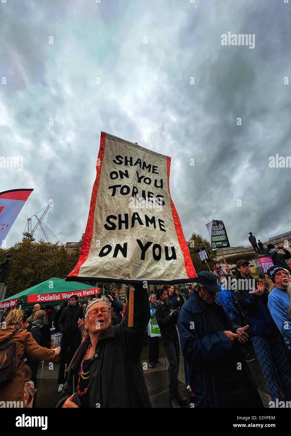 Vergogna su di te, vergogna su di te! Banner alla manifestazione anti-austerità a Trafalgar Square, Londra, il 5th novembre 2022. Sindacati straordinari si sono riuniti per chiedere l’elezione generale nel Regno Unito - Immagine stock catturata con smartphone
