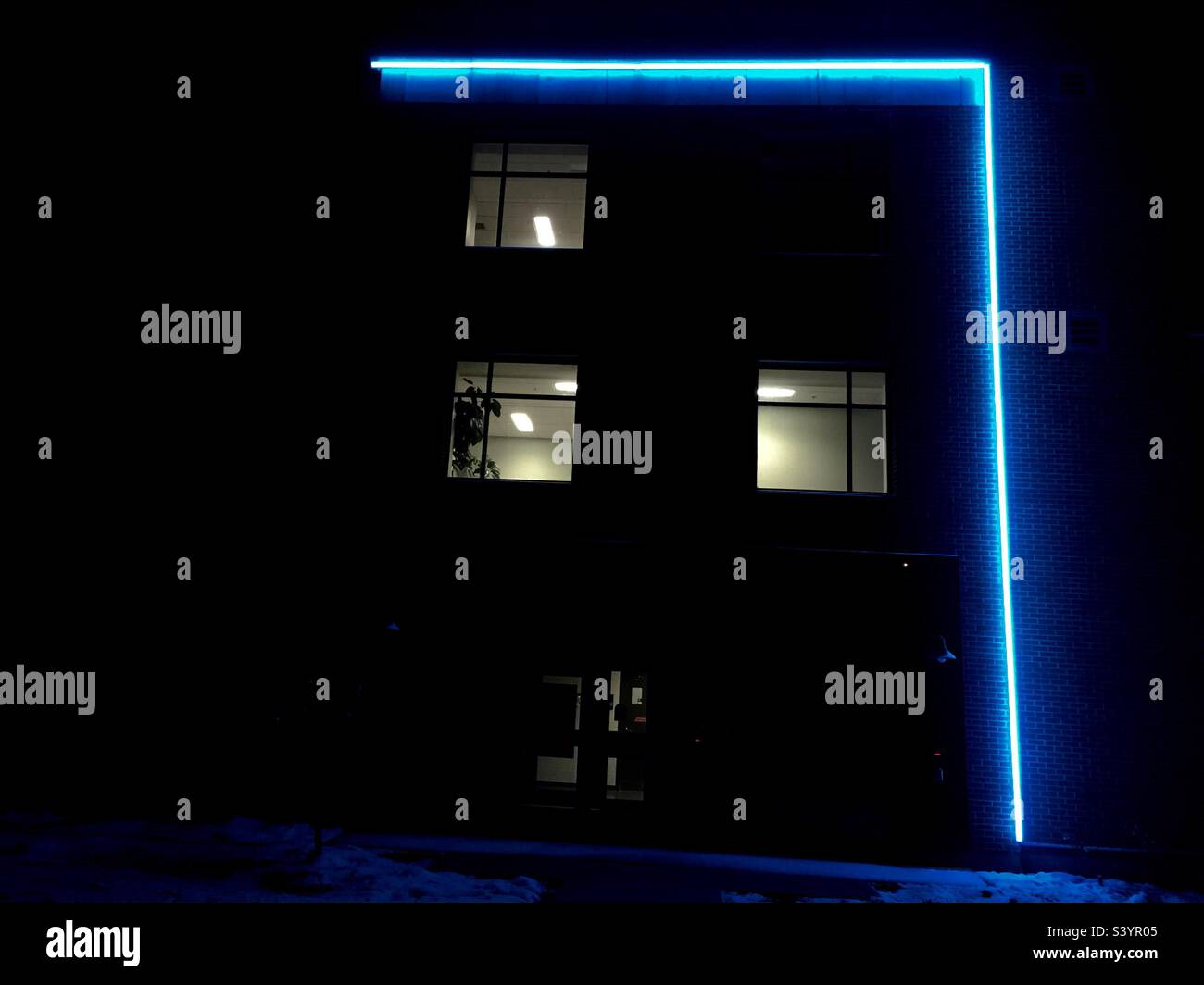 Casa con il neon blu. Tre finestre. Spettrale. - Immagine stock catturata con smartphone