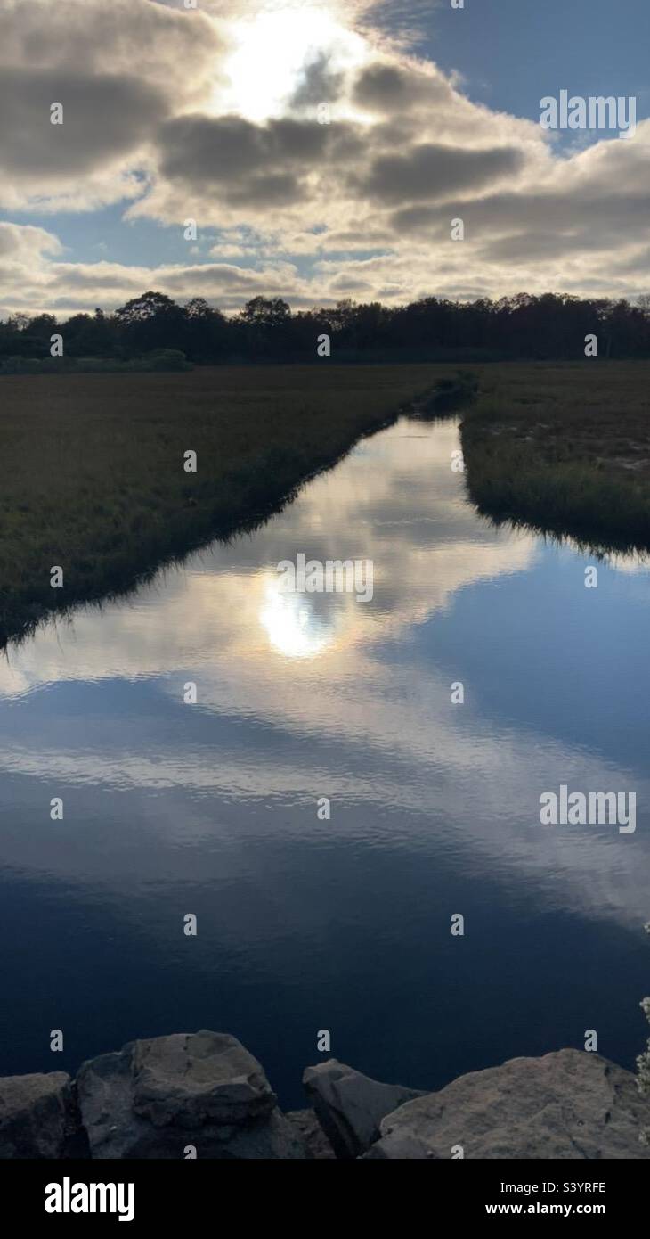 Tramonto sull'acqua a Waterford, Connecticut nel mese di ottobre. Riflesso del cielo nell'acqua. - Immagine stock catturata con smartphone