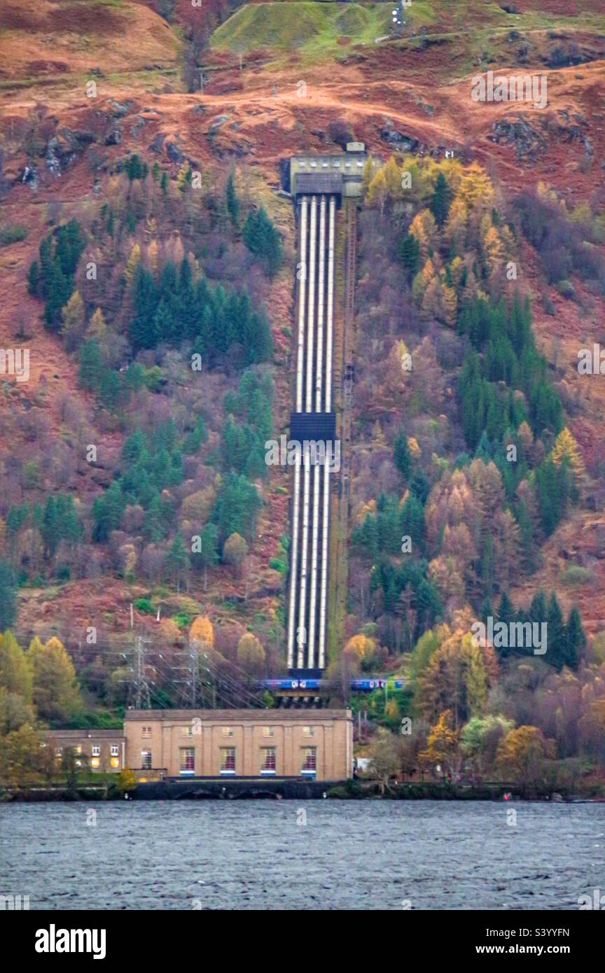 Treno Scotrail che passa dalla centrale elettrica di Loch Sloy - Immagine stock catturata con smartphone