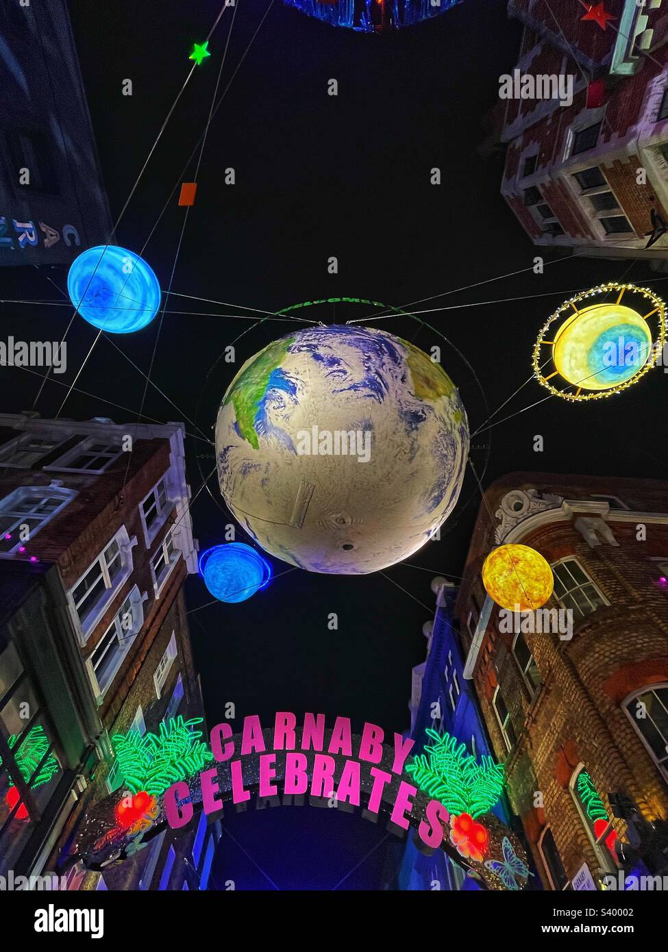 Primo piano delle luci natalizie Carnaby Celebration a Soho London. Il globo e i pianeti alti sopra le strette strade storiche forniscono uno sfondo e un'atmosfera incredibili per l'ospitalità Foto Stock