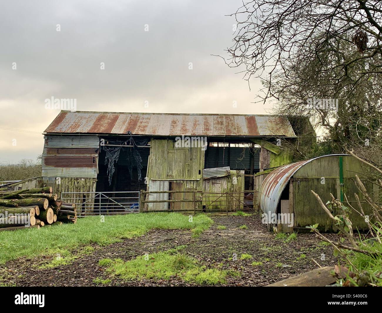 Vecchio fienile di legno e ferro corrugato campagna per lo stoccaggio in fattoria, Somerset Inghilterra durante l'inverno Foto Stock