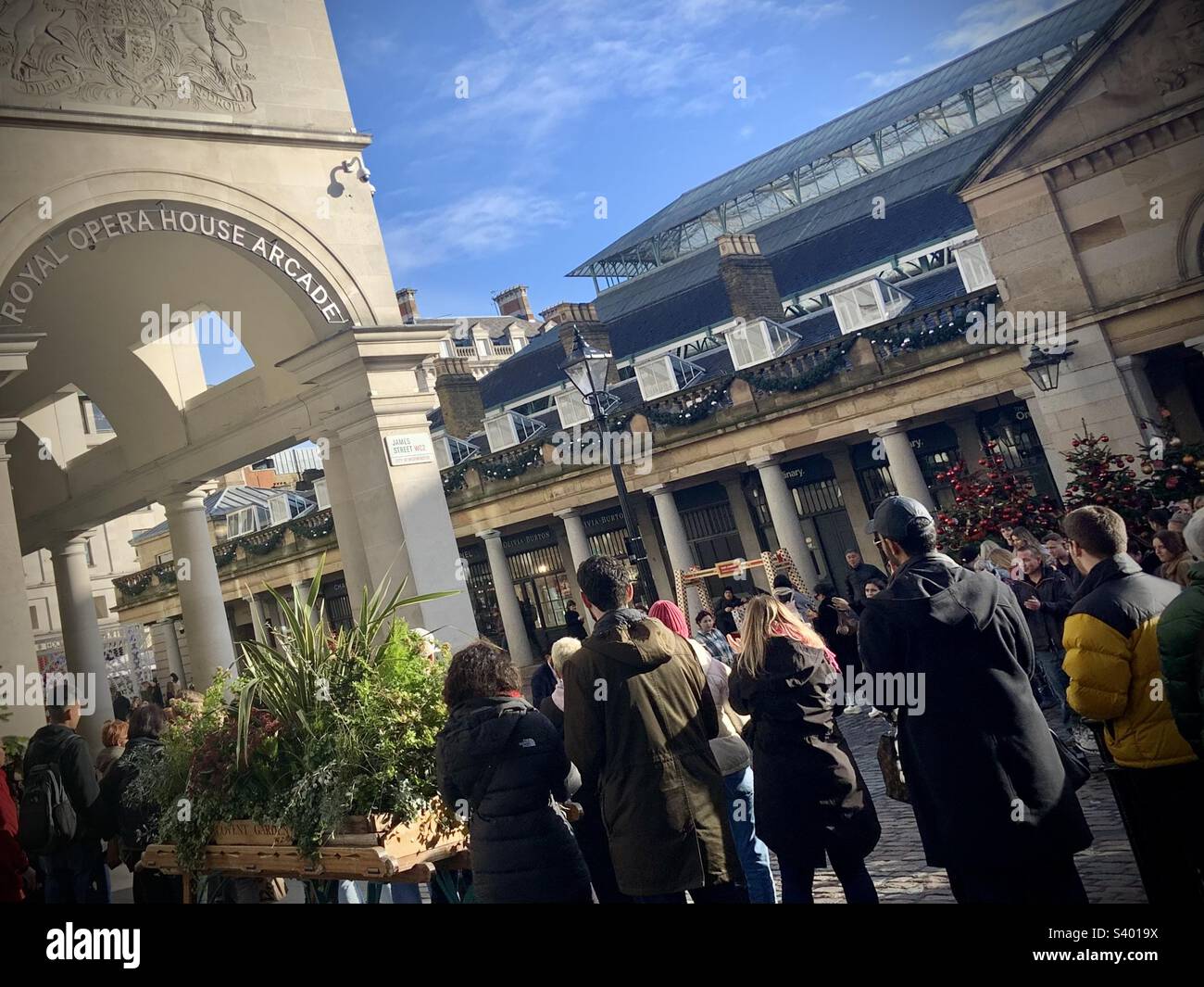 Persone che guardano un atto di strada a Covent Garden presso la galleria Royal Opera House Foto Stock