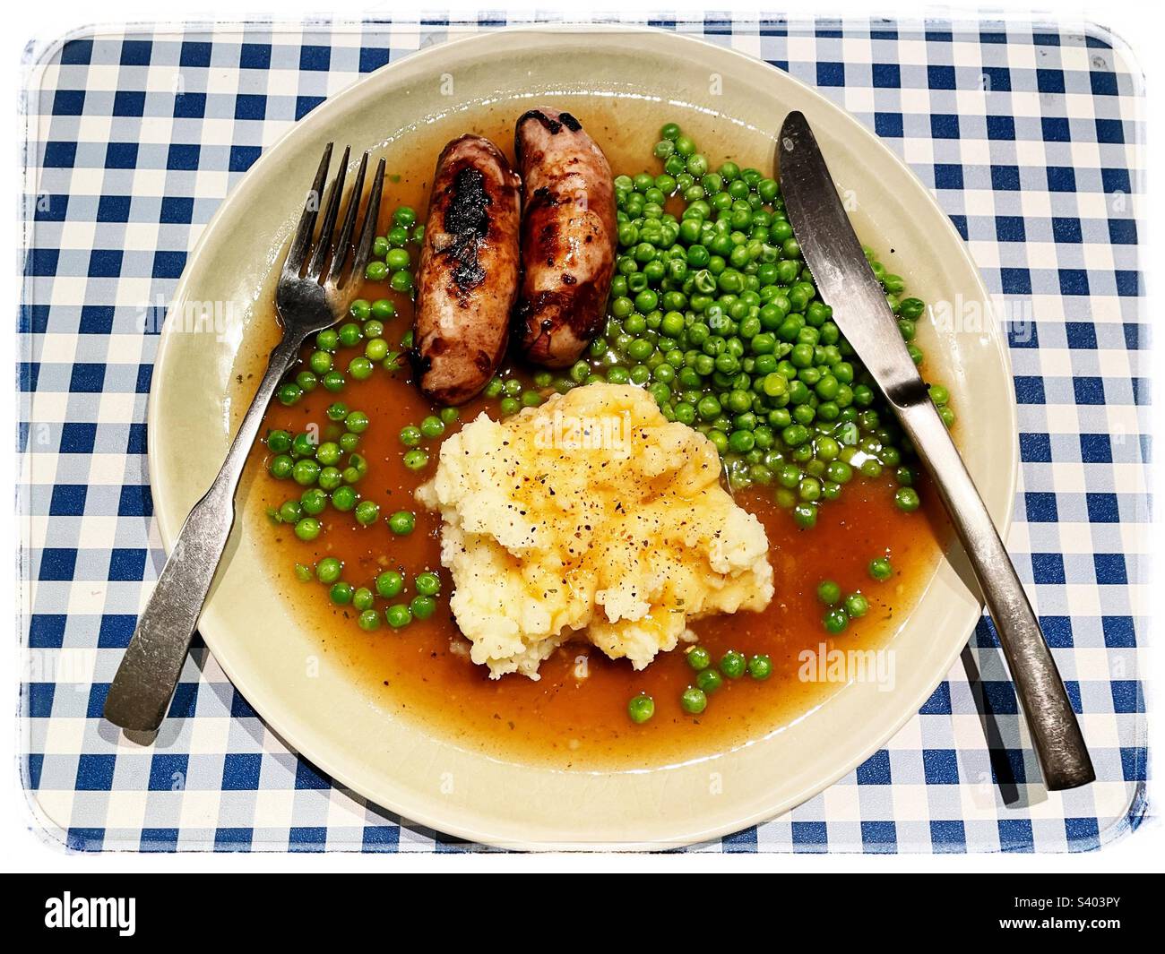 Sussages purè di piselli di patate e sugo Foto Stock