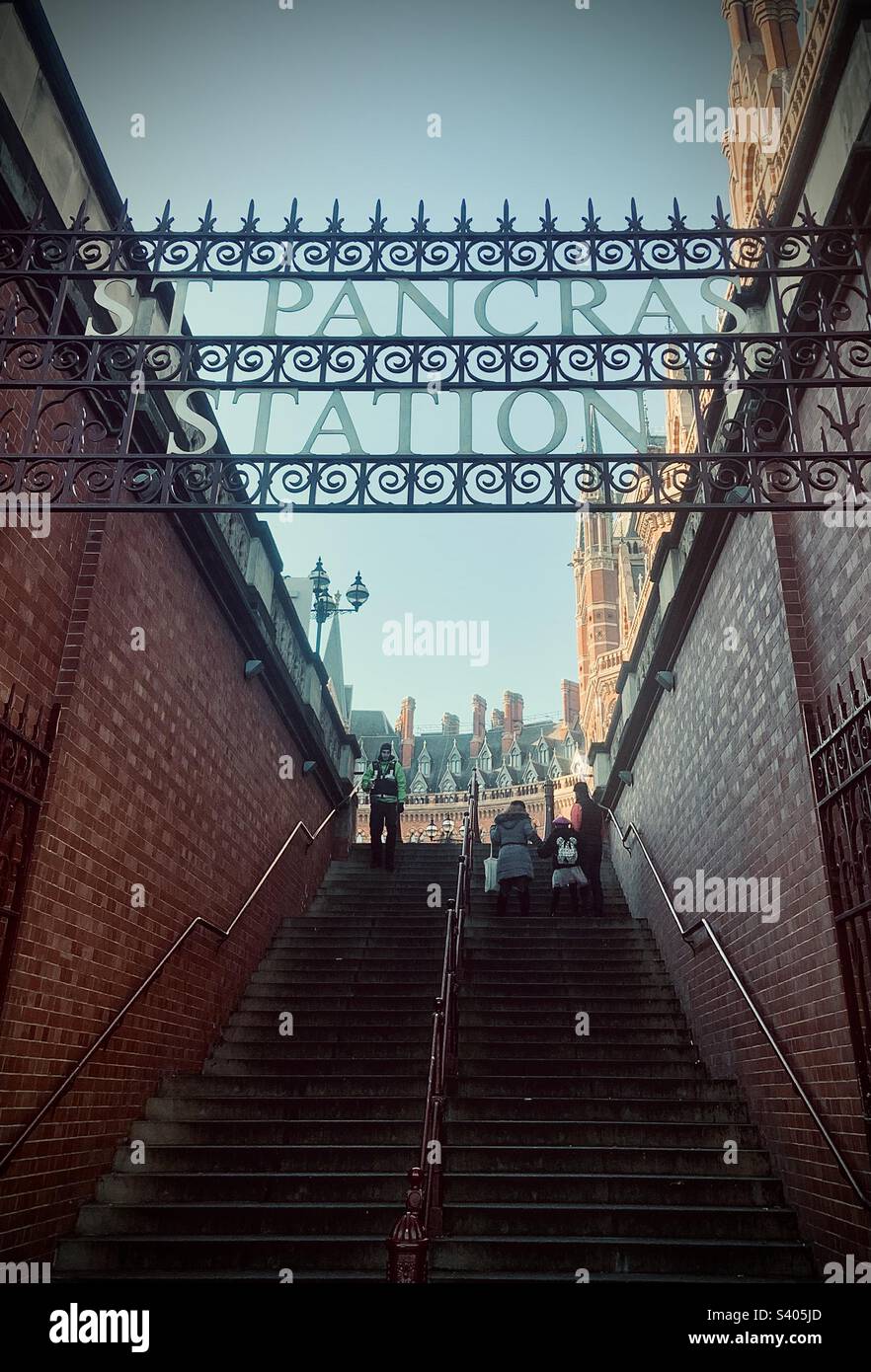 Persone sulla scalinata alla stazione di St Pancras. Insegne decorate in alto Foto Stock