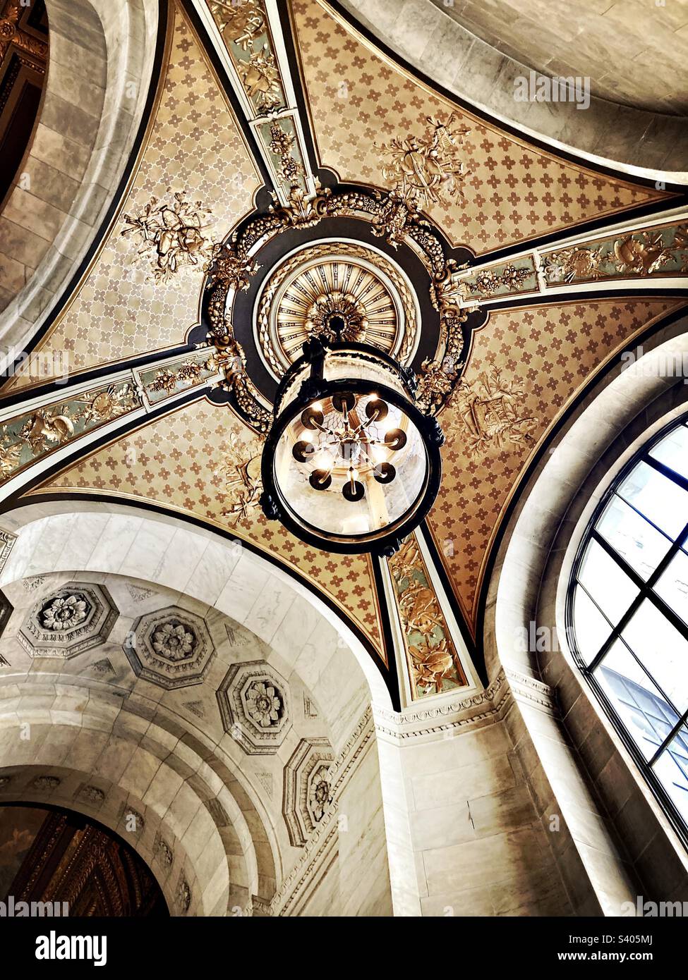 Guardando sul soffitto con una luce sospesa all'interno della New York Public Library sulla Fifth Avenue nel centro di Manhattan - Immagine stock catturata con smartphone