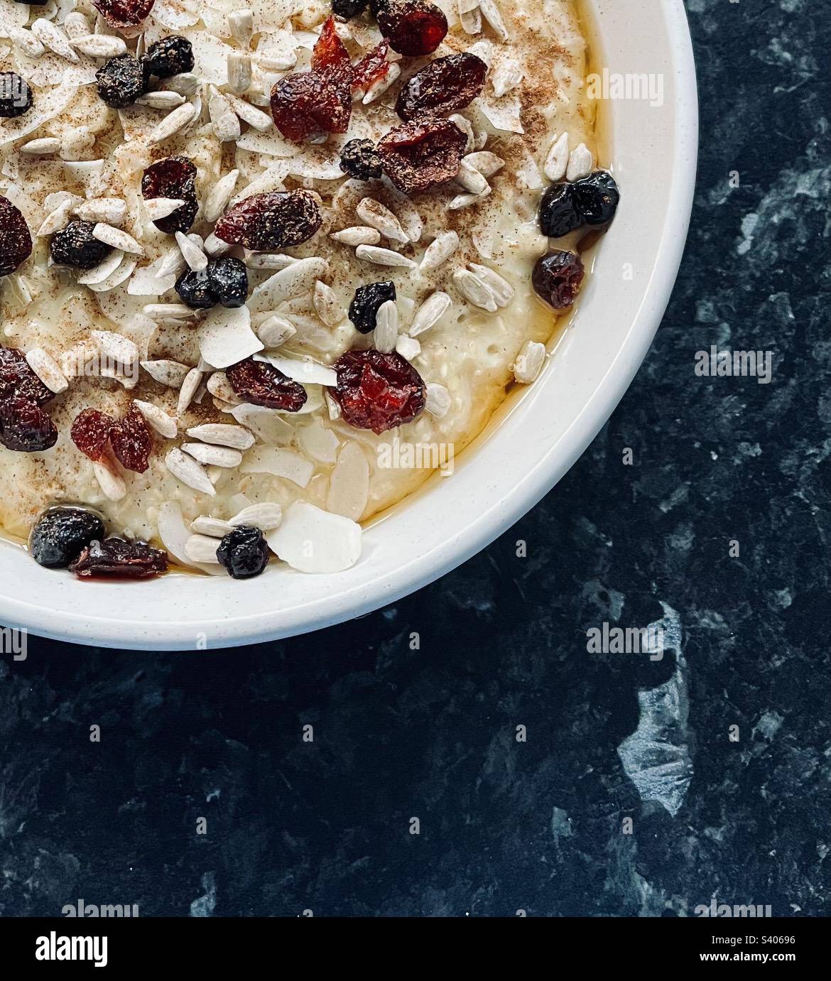 Colazione sana. Avena di porridge con bacche, semi e miele. Foto Stock