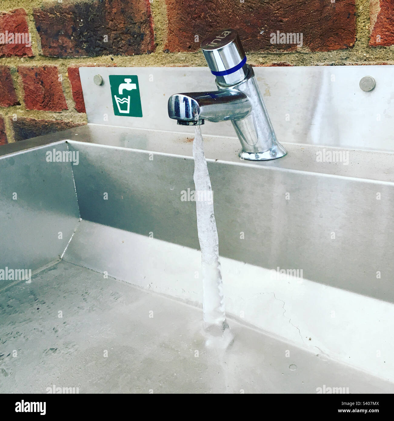 Una colonna d'acqua congelata da un rubinetto sgocciolante in una mattina fredda e gelida a Hampton, Londra, Regno Unito. Foto Stock