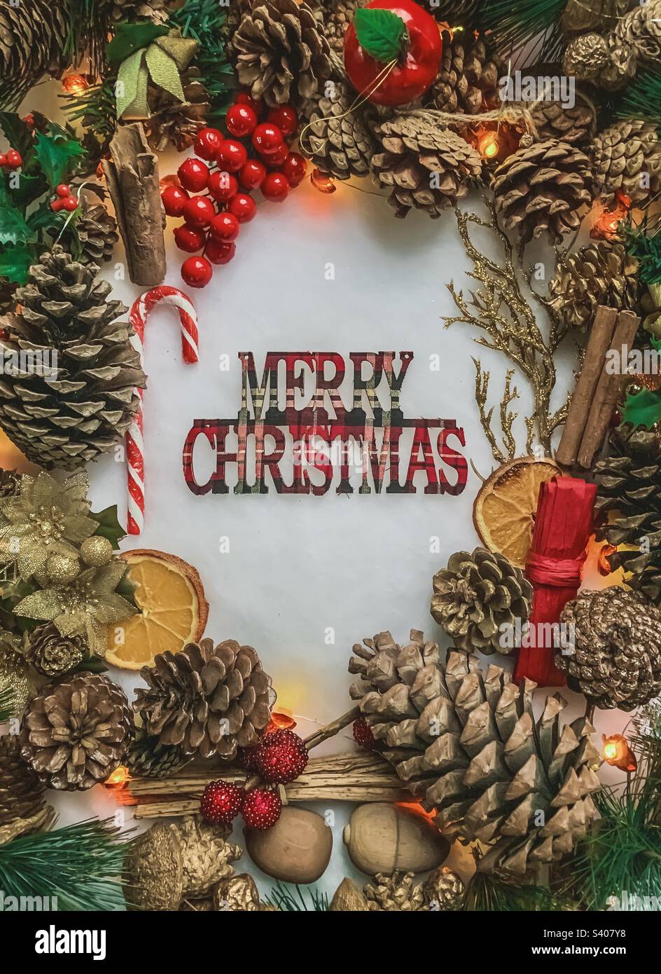 Un espositore festivo intorno a lettere tartan che recita Merry Christmas - Immagine stock catturata con smartphone