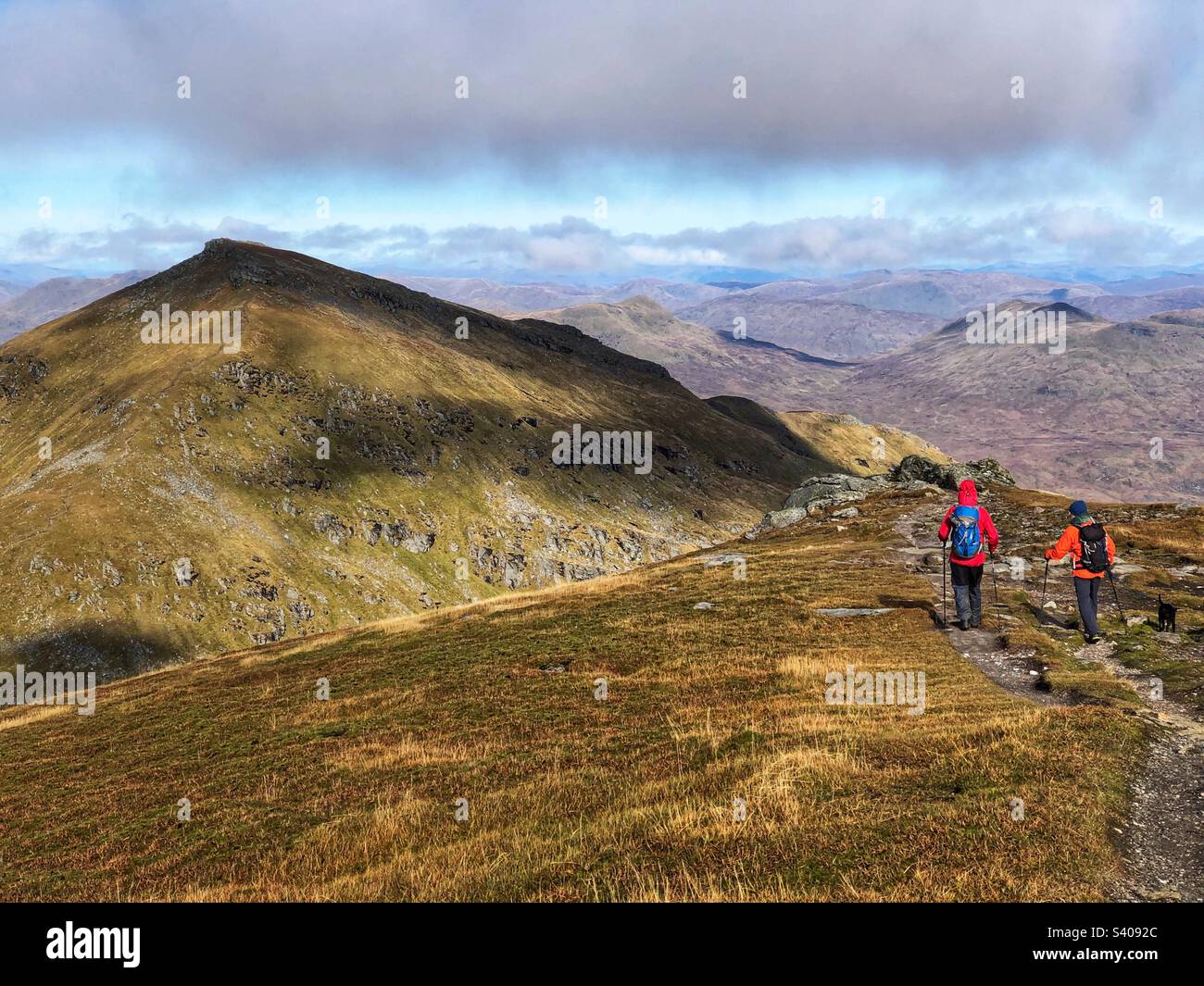 Camminatori che lasciano la cima di Munro Stob Binnein, con una vista verso la cima adiacente di ben More, Crianlarich Scozia - Immagine stock catturata con smartphone