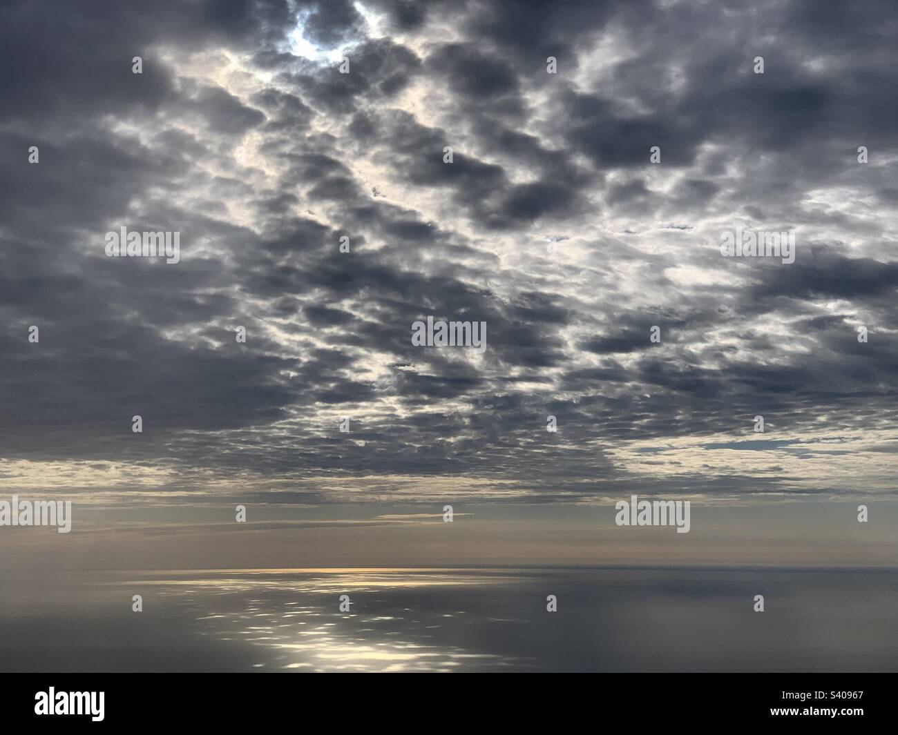 Nuvole e luce solare drammatiche viste mentre in un aereo che scende verso Chicago, Illinois - Immagine stock catturata con smartphone