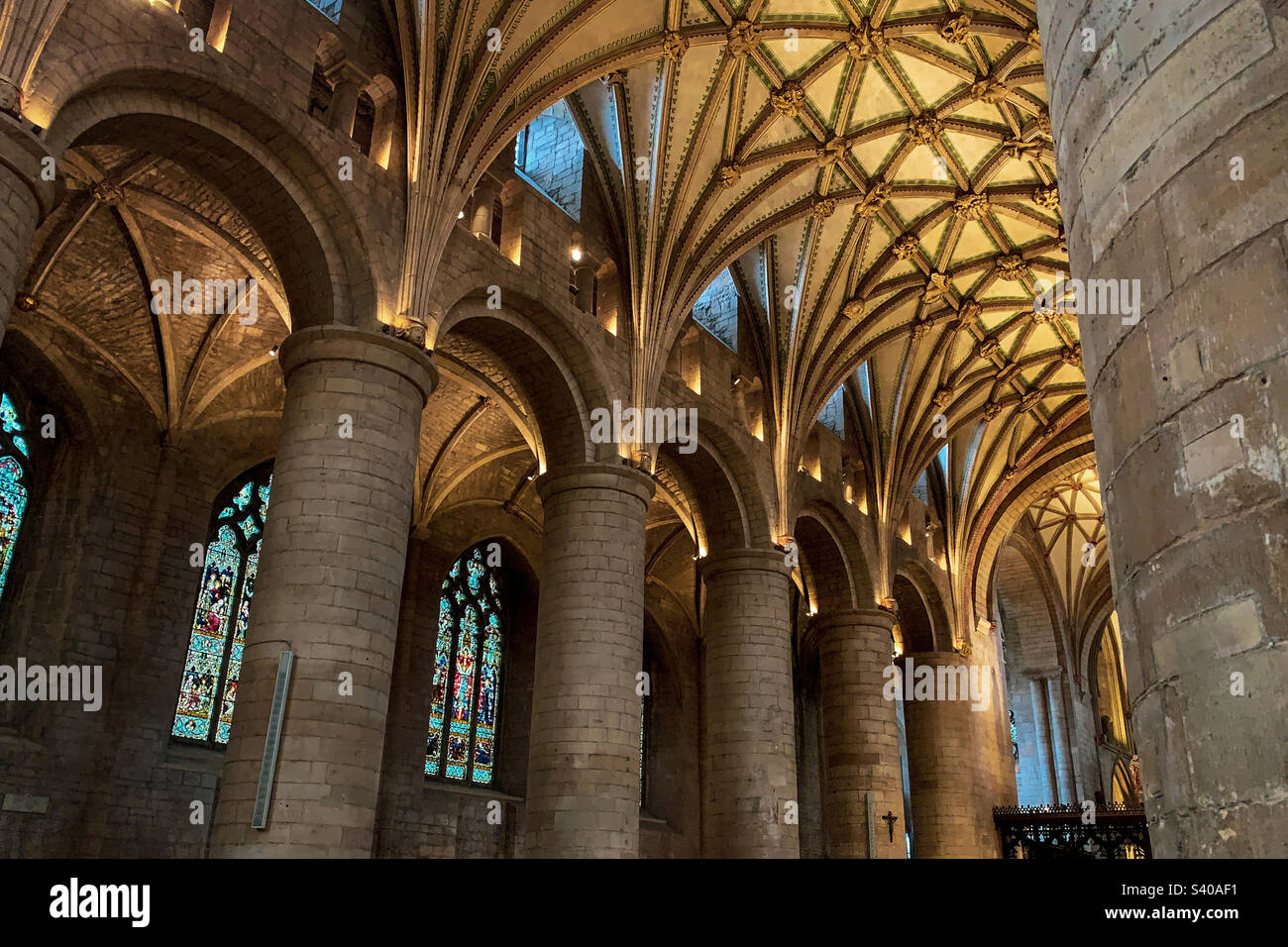 Decorazioni interne splendidamente ornate che guardano verso l'alto all'interno dell'abbazia di Tewkesbury, Gloucestershire, Regno Unito. Una foto di un telefono cellulare con post-elaborazione di un telefono o di un tablet. - Immagine stock catturata con smartphone