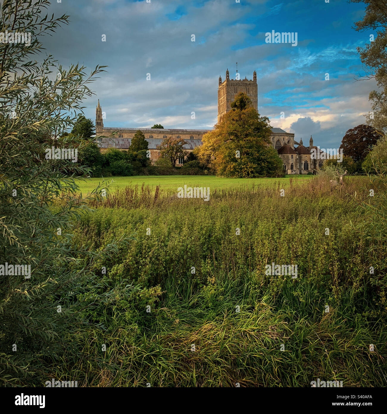 I colori autunnali arrivano all'abbazia di Tewkesbury in un bellissimo pomeriggio di ottobre, nel Gloucestershire, Regno Unito. Una foto di un telefono cellulare con post-elaborazione di un telefono o di un tablet. - Immagine stock catturata con smartphone