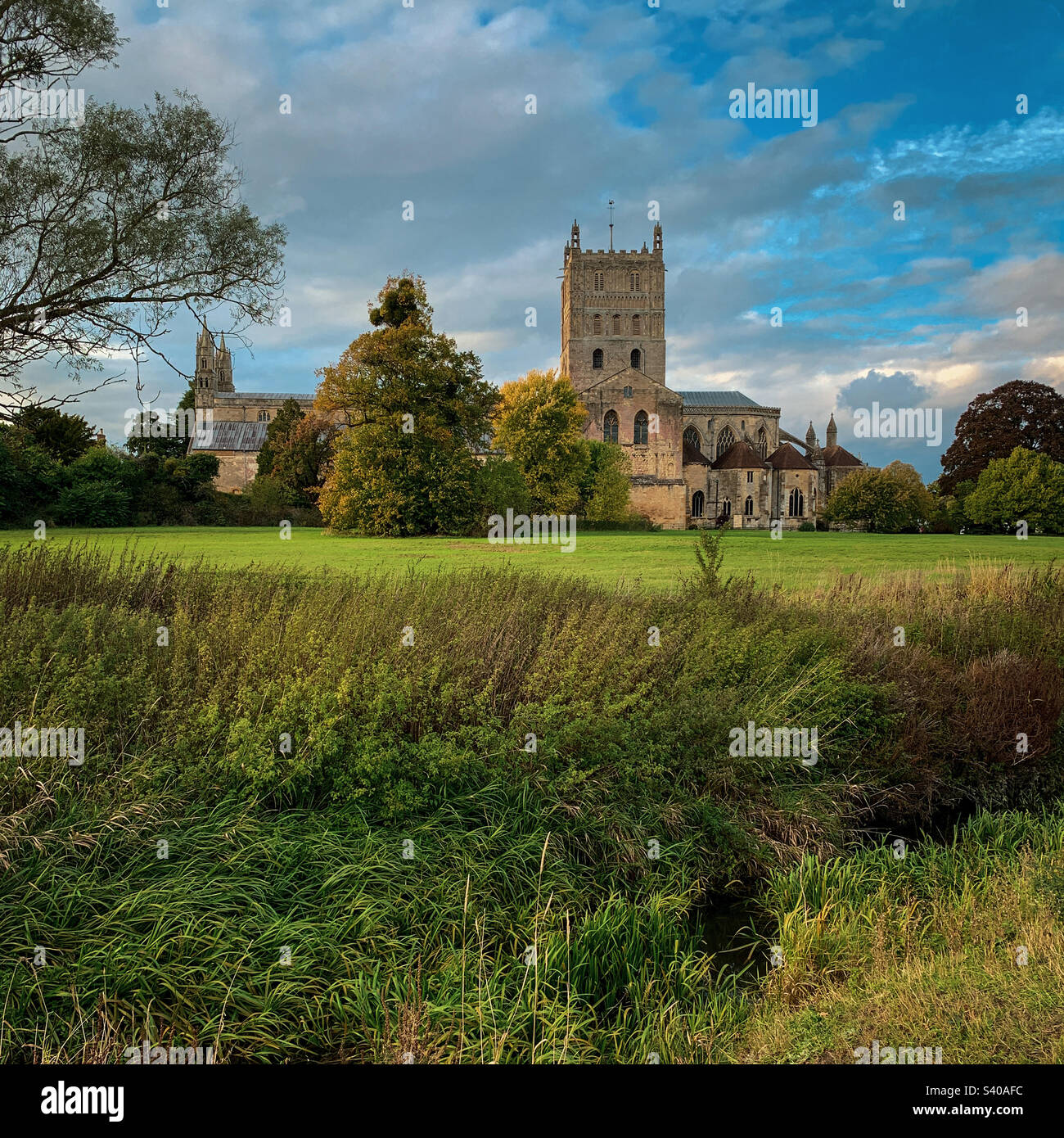 I colori autunnali arrivano all'abbazia di Tewkesbury in un bellissimo pomeriggio di ottobre, nel Gloucestershire, Regno Unito. Una foto di un telefono cellulare con post-elaborazione di un telefono o di un tablet. - Immagine stock catturata con smartphone