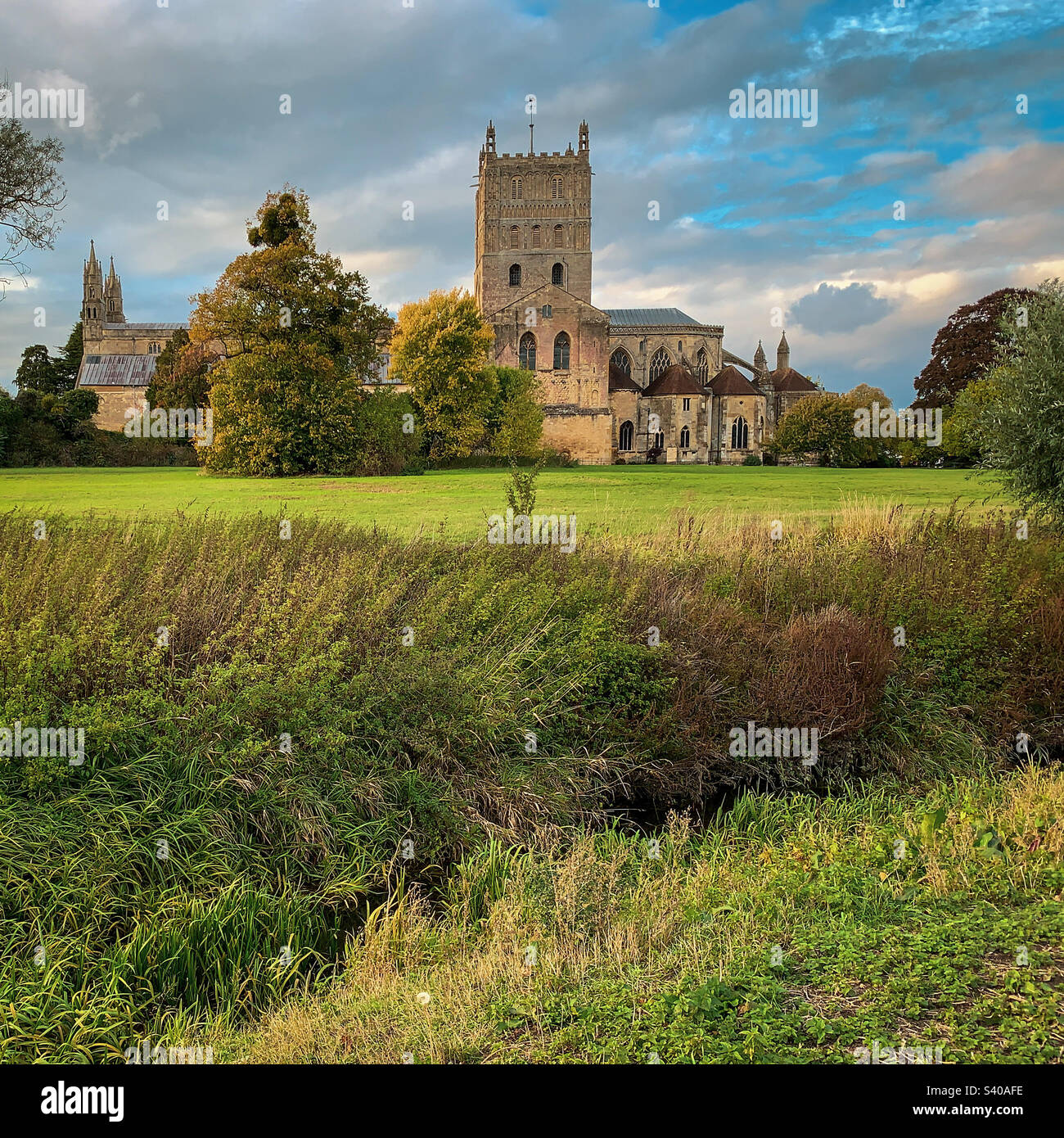 I colori autunnali arrivano all'abbazia di Tewkesbury in un bellissimo pomeriggio di ottobre, nel Gloucestershire, Regno Unito. Una foto di un telefono cellulare con post-elaborazione di un telefono o di un tablet. - Immagine stock catturata con smartphone