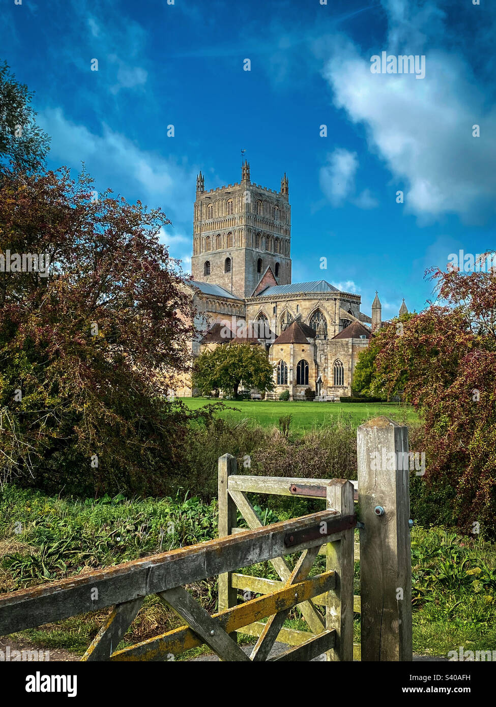 I colori autunnali arrivano all'abbazia di Tewkesbury in un bellissimo pomeriggio di ottobre, nel Gloucestershire, Regno Unito. Una foto di un telefono cellulare con post-elaborazione di un telefono o di un tablet. - Immagine stock catturata con smartphone