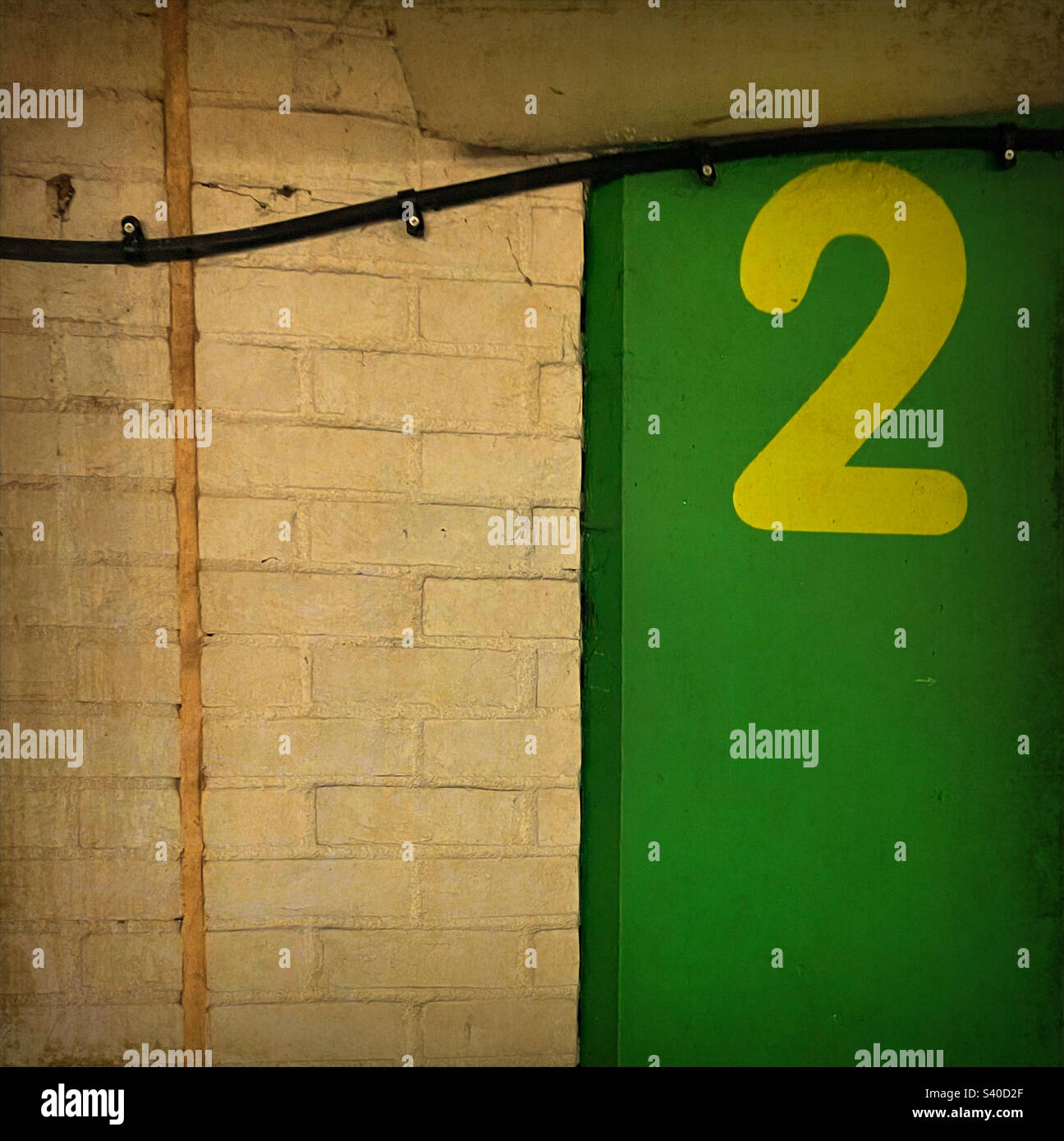 Il numero due su una parete verde Foto Stock