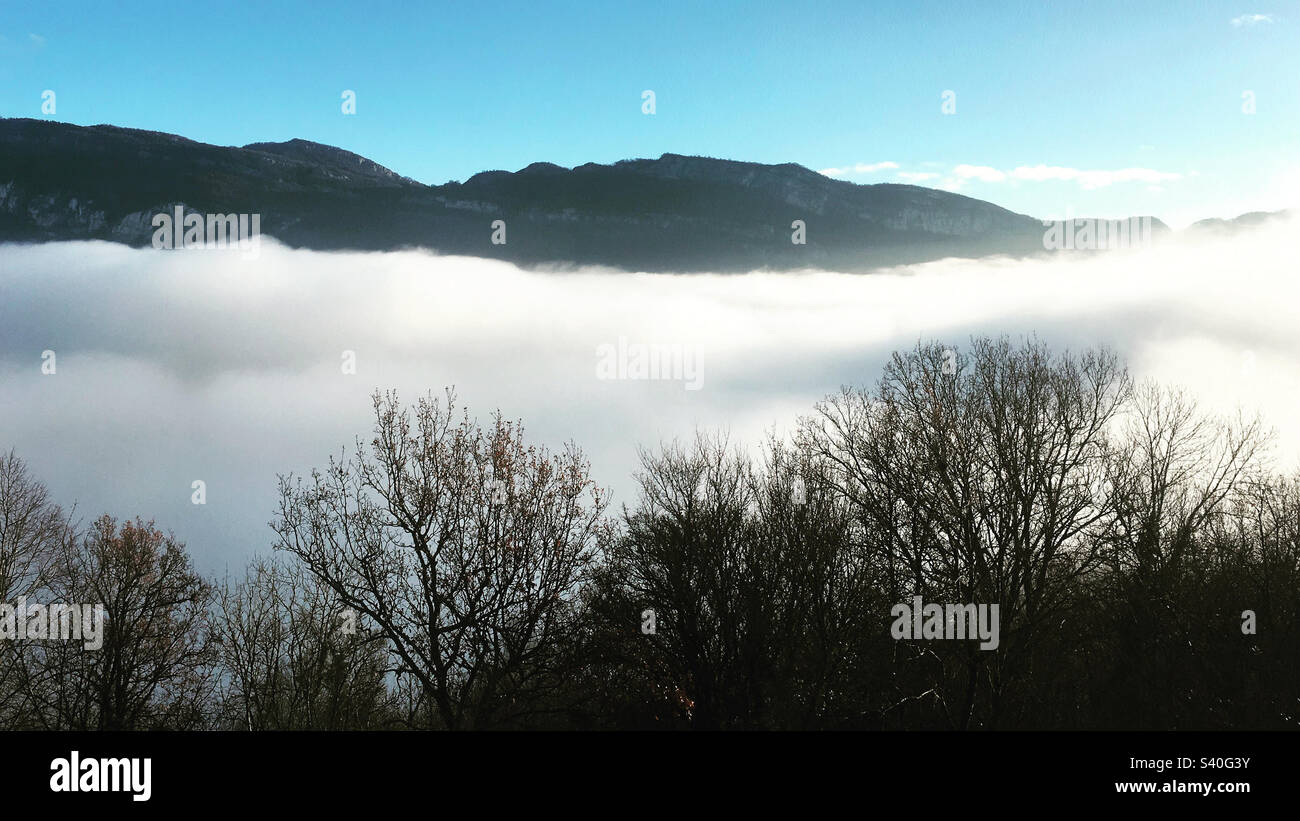 La nebbia mattutina riempie la valle sotto un cielo azzurro soleggiato nel sud-est della Francia. Foto Stock