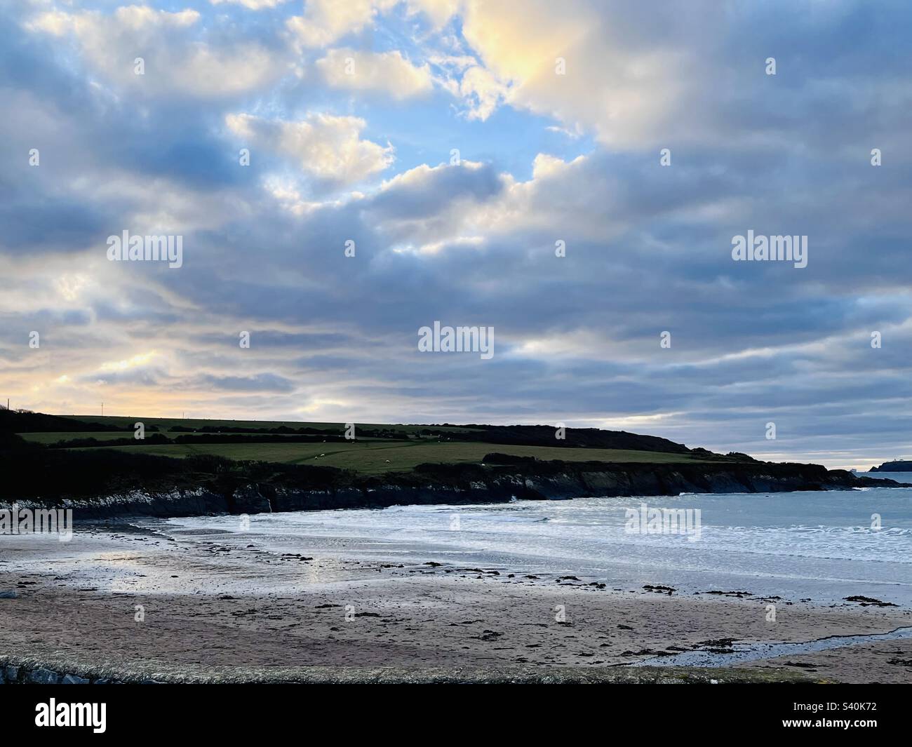 Spiaggia isolata nel Pembrokeshire, Galles occidentale, Regno Unito, a Sunset Over the New Year Foto Stock