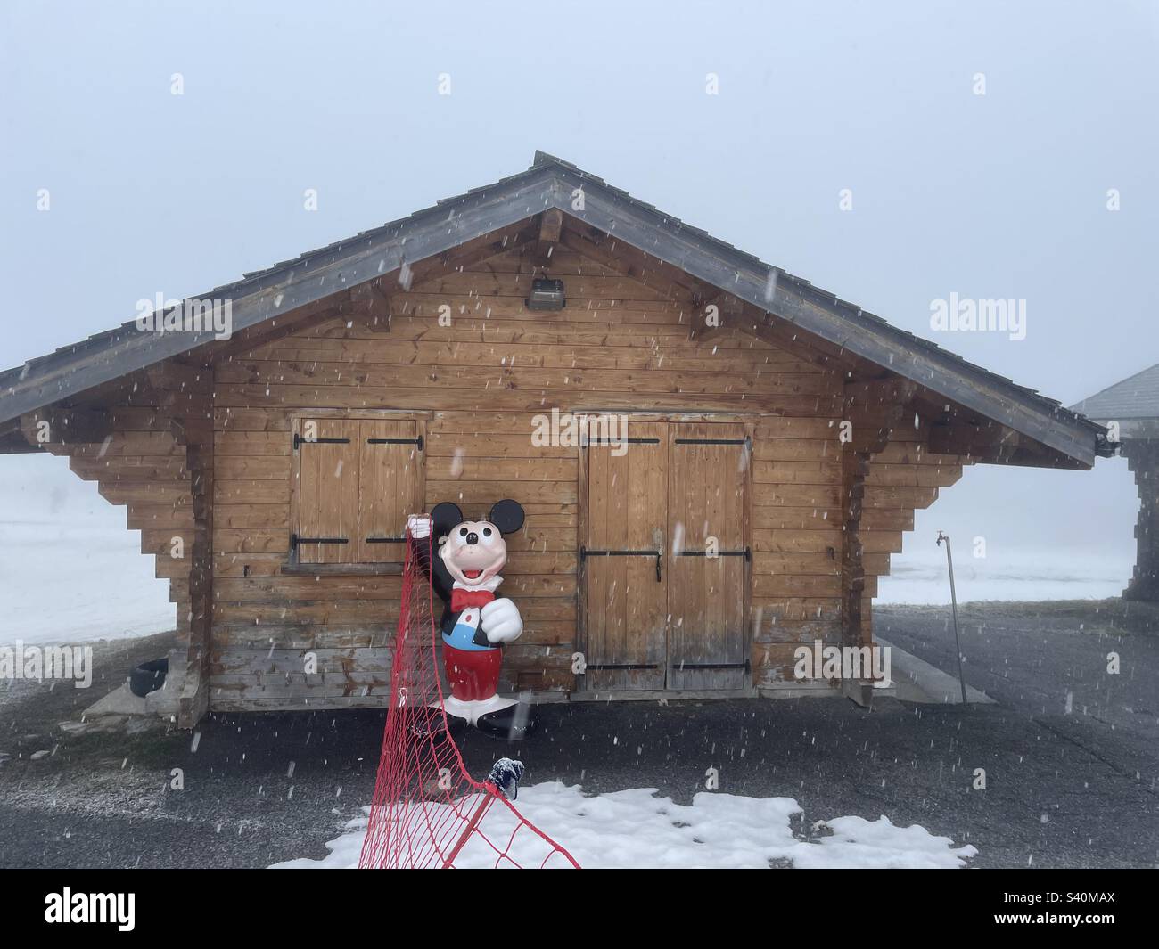 Rifugio sciistico nelle alpi francesi con statua di Topolino all'esterno - Immagine stock catturata con smartphone