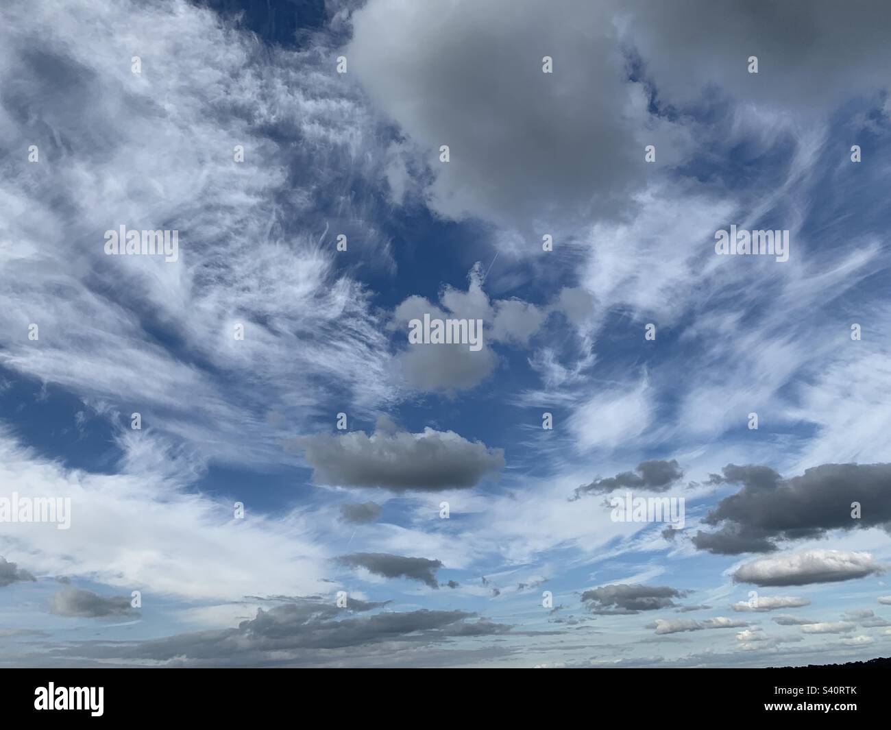 Cumulus e le nuvole di cirrus sparsi in un cielo estivo blu luminoso nel Somerset, Inghilterra Foto Stock