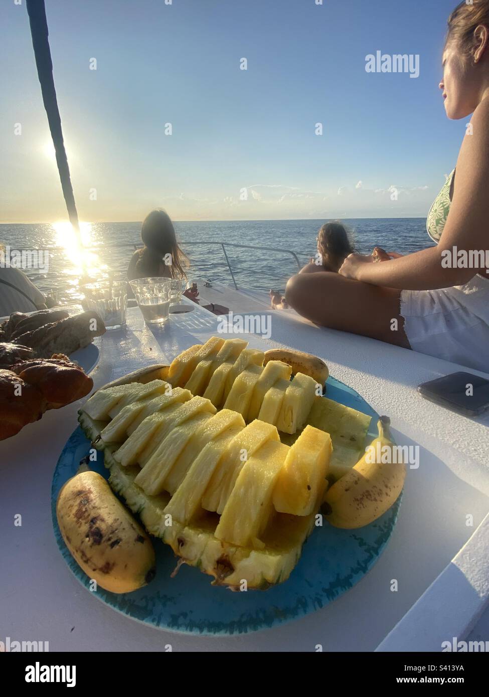 Spuntini di ananas per gli ospiti sul ponte di un catamarano in barca a vela lungo la costa della Costa Rica - Immagine stock catturata con smartphone