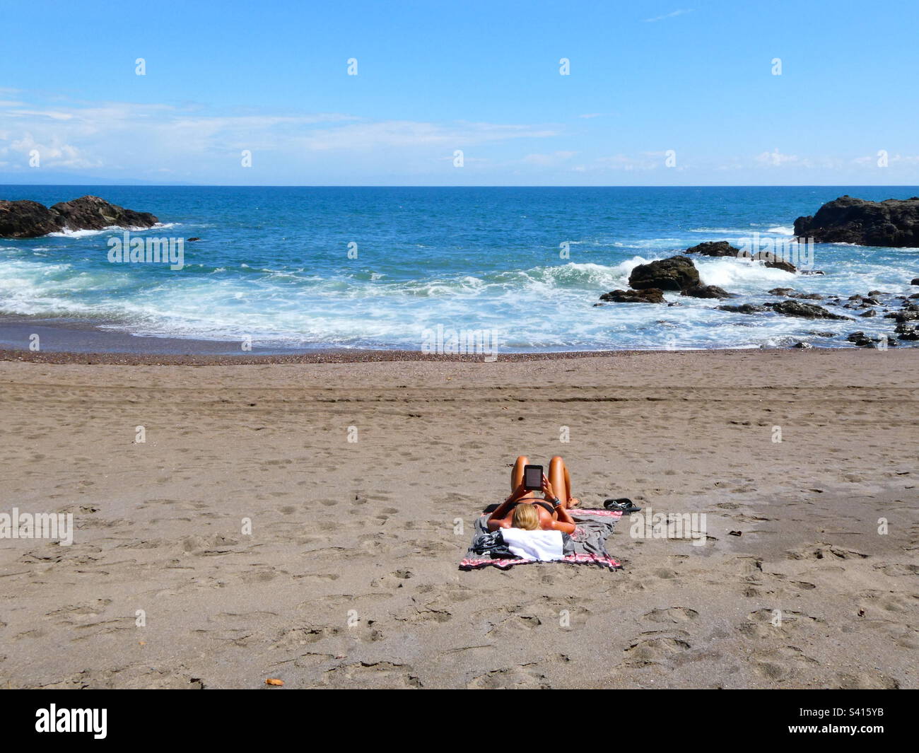 Una donna ama passare il tempo da sola su una spiaggia tranquilla vicino a Montezuma in Costa Rica Foto Stock