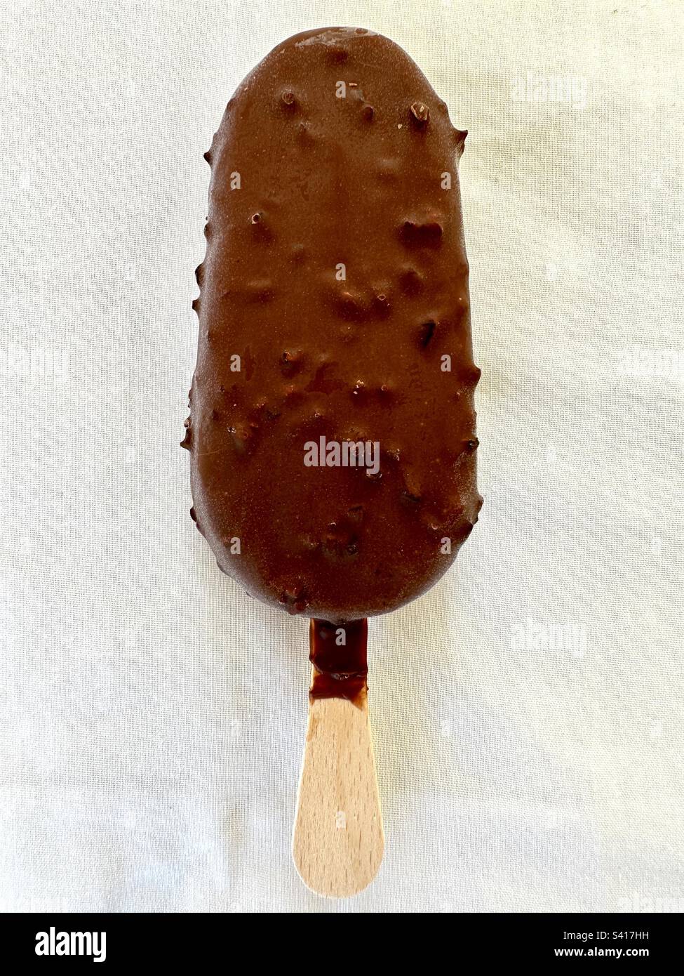 Gelato alla vaniglia rivestito di cioccolato su un bastoncino Foto Stock