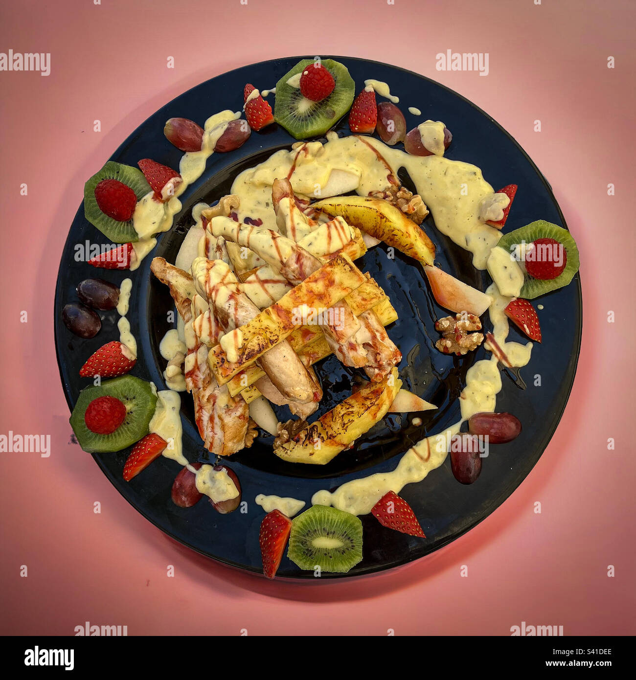 Pollo Hawai su un piatto nero - Immagine stock catturata con smartphone