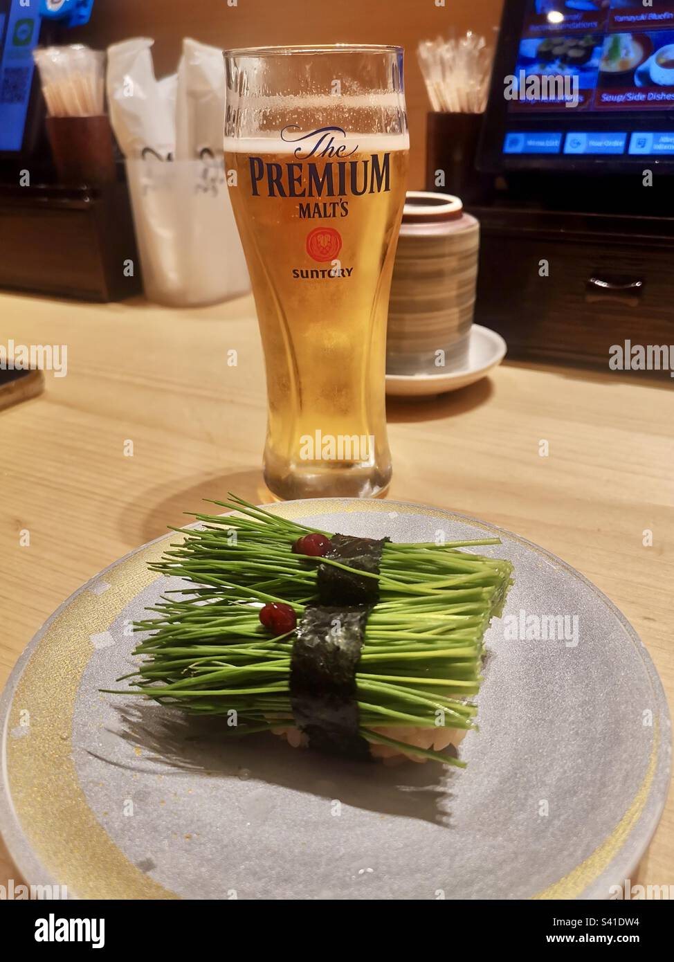 Il sushi di erba cipollina e un bicchiere di birra Suntory. Foto Stock