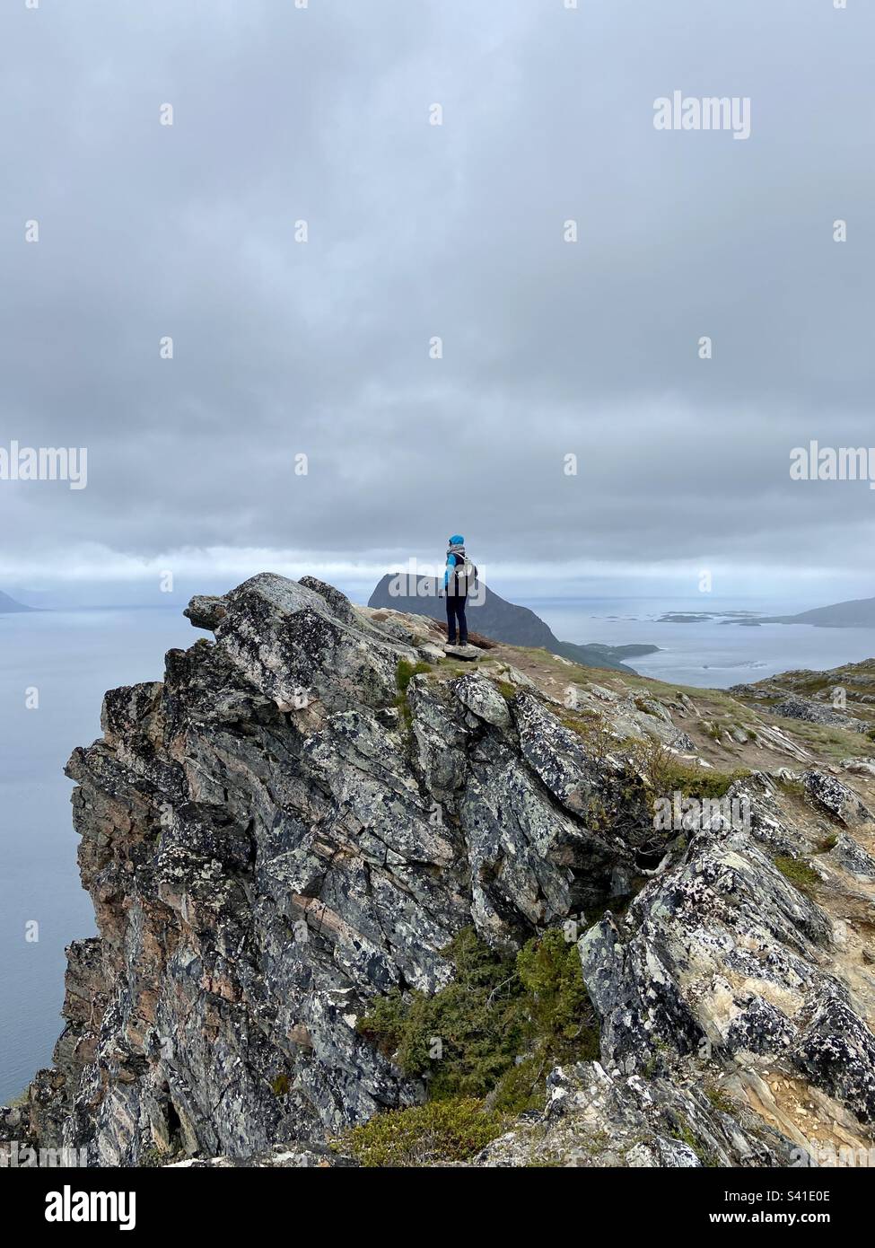 In piedi sulla cima della montagna Keipen nelle isole Lofoten, Norvegia settentrionale e guardando lontano in una giornata estiva nuvolosa/piovosa. Foto Stock