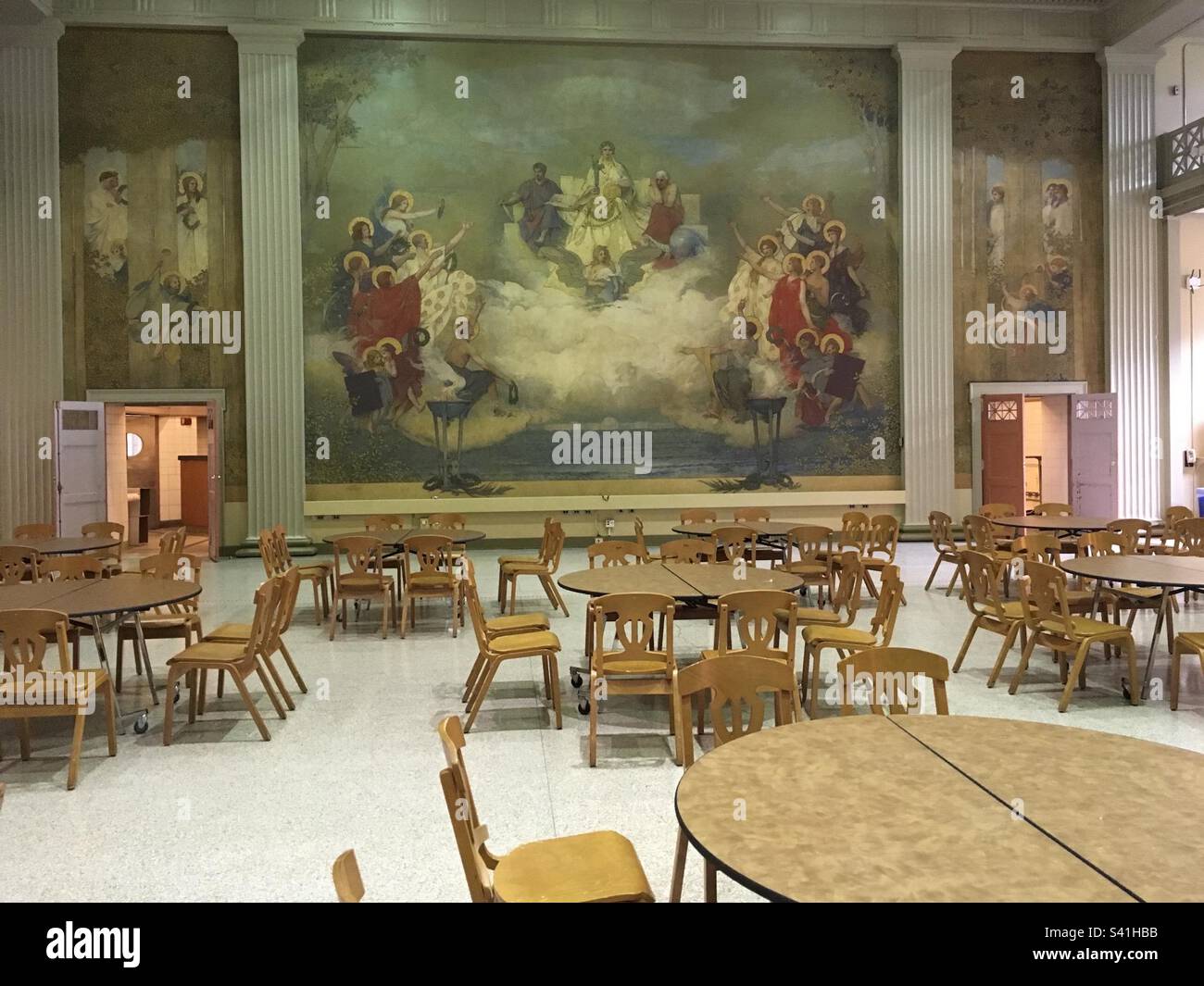 All'interno della sala da pranzo vuota del campus del Massachusetts Institute of Technology (MIT). La foto mostra pareti, dipinti, murali, sedie e tavoli. - Immagine stock catturata con smartphone