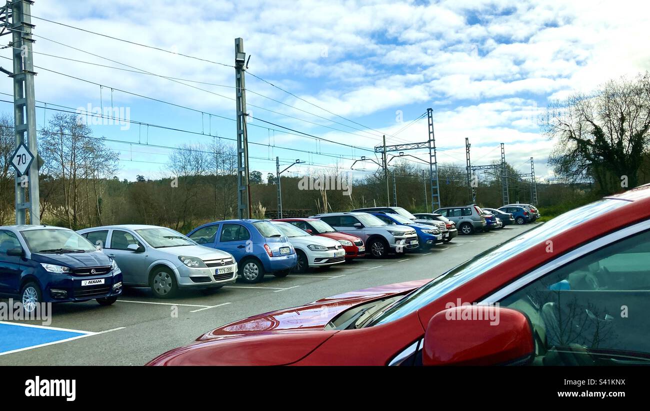 Parcheggio completo in una stazione ferroviaria in Spagna con cavi elettrici sospesi Foto Stock