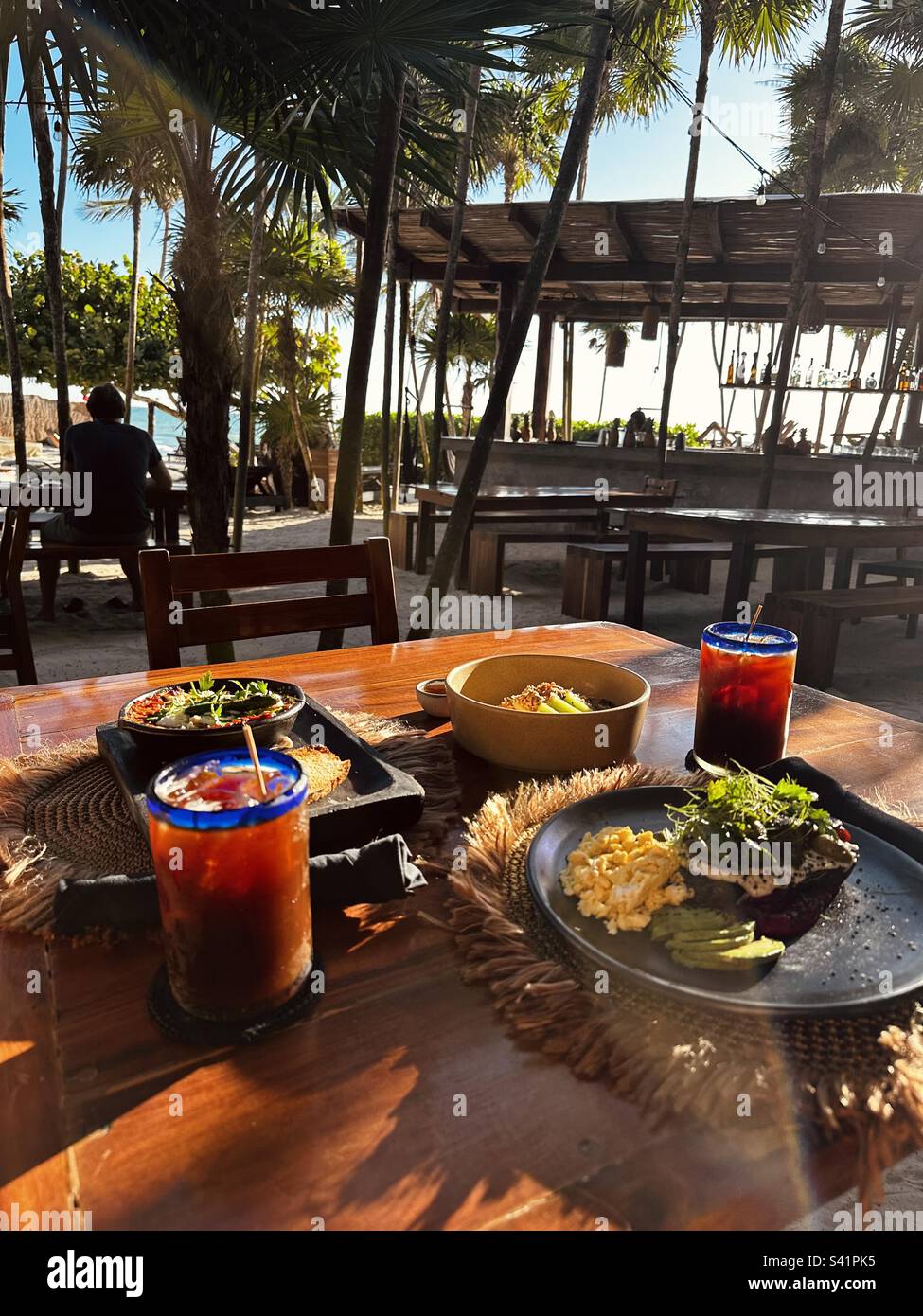 La colazione include uova strapazzate, toast avokado e caffè ghiacciato a Tulum Beach, Tulum, Messico Foto Stock