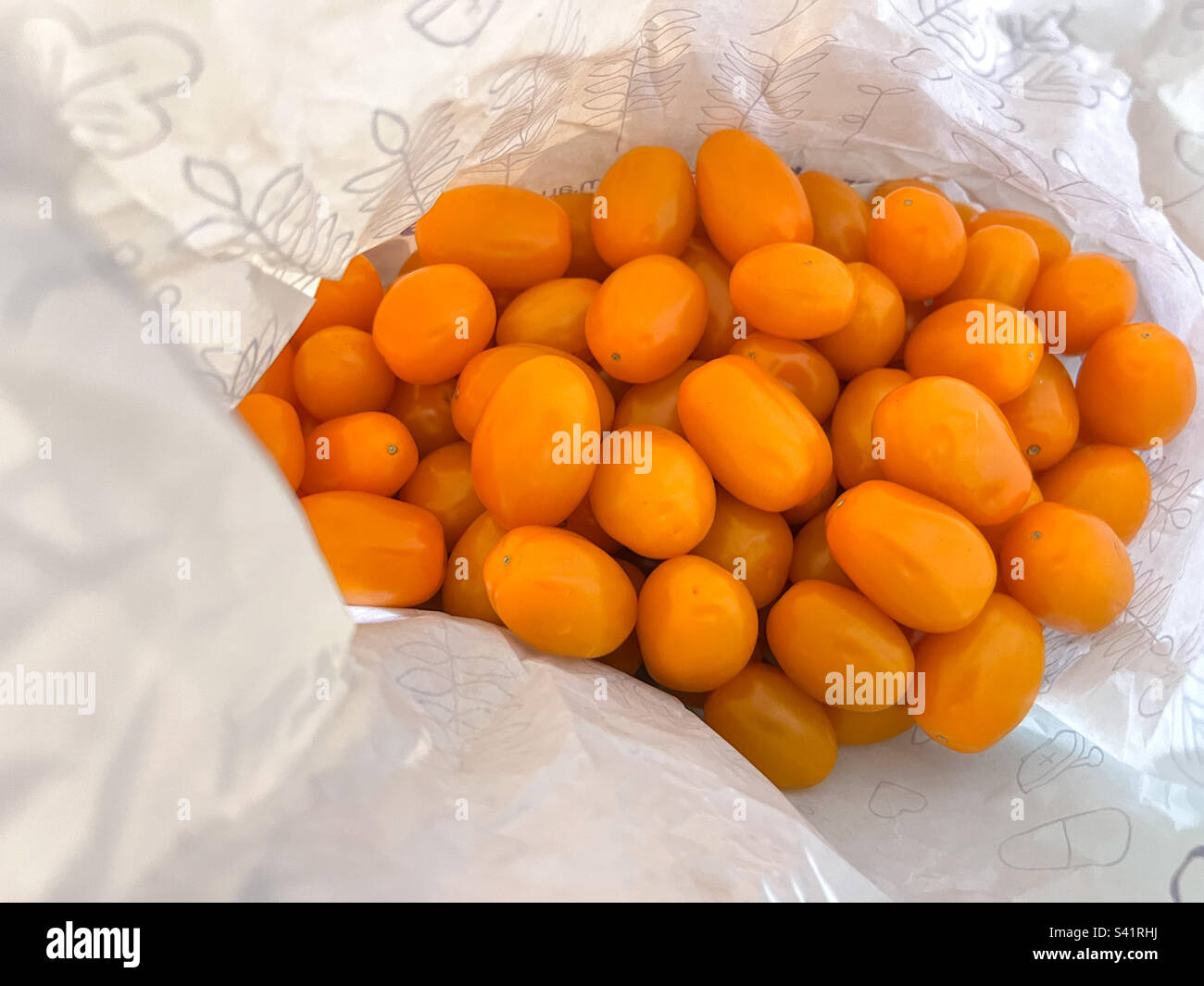 Pomodori ciliegini maturi in sacchetto di plastica Foto Stock